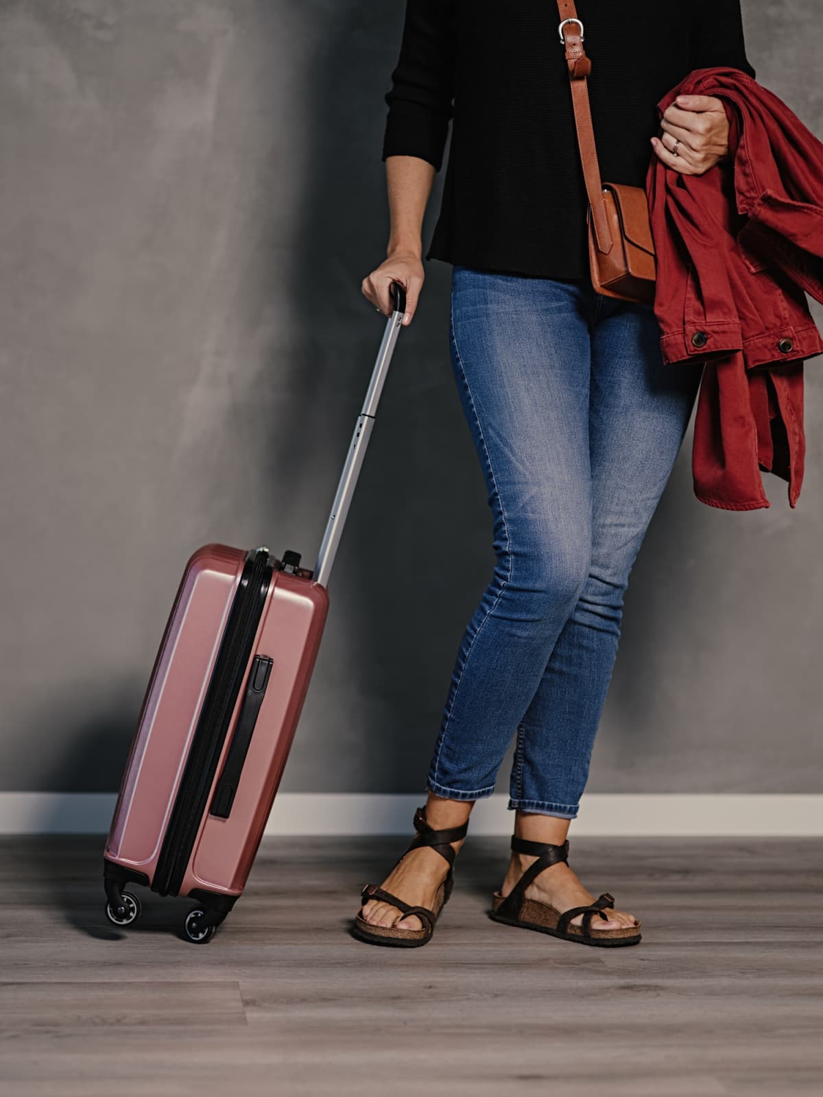 Woman with cabin suitcase bags ready to travel
Photo taken indoors of casual woman ready for vacation with carry-on luggage