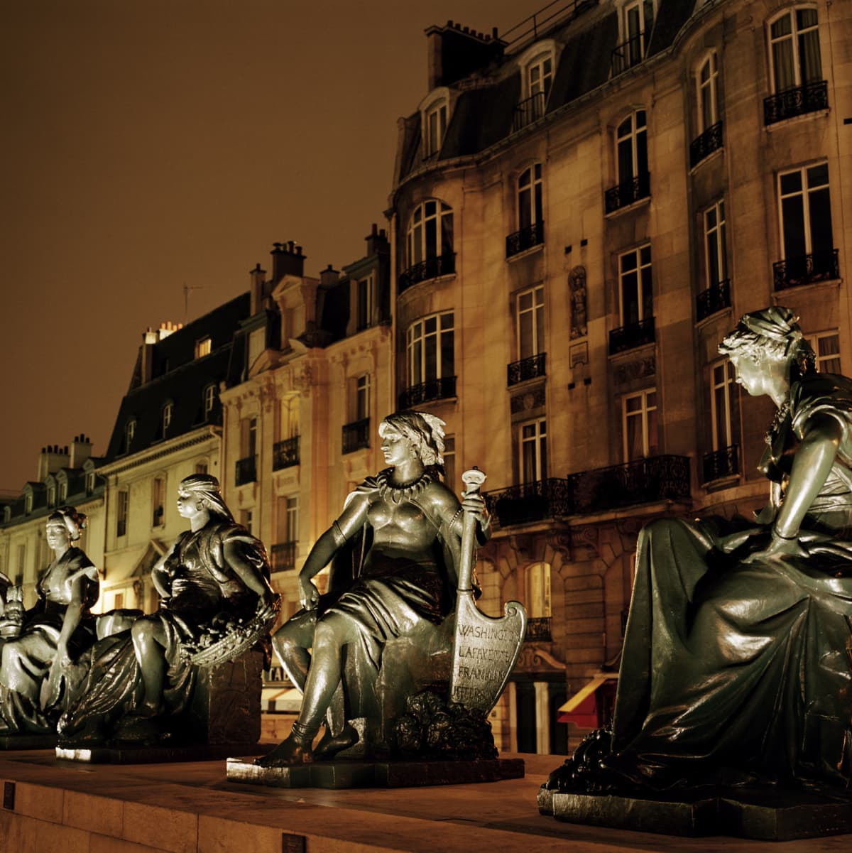 Exterior view at night of the Musee d'Orsay and statues in Paris