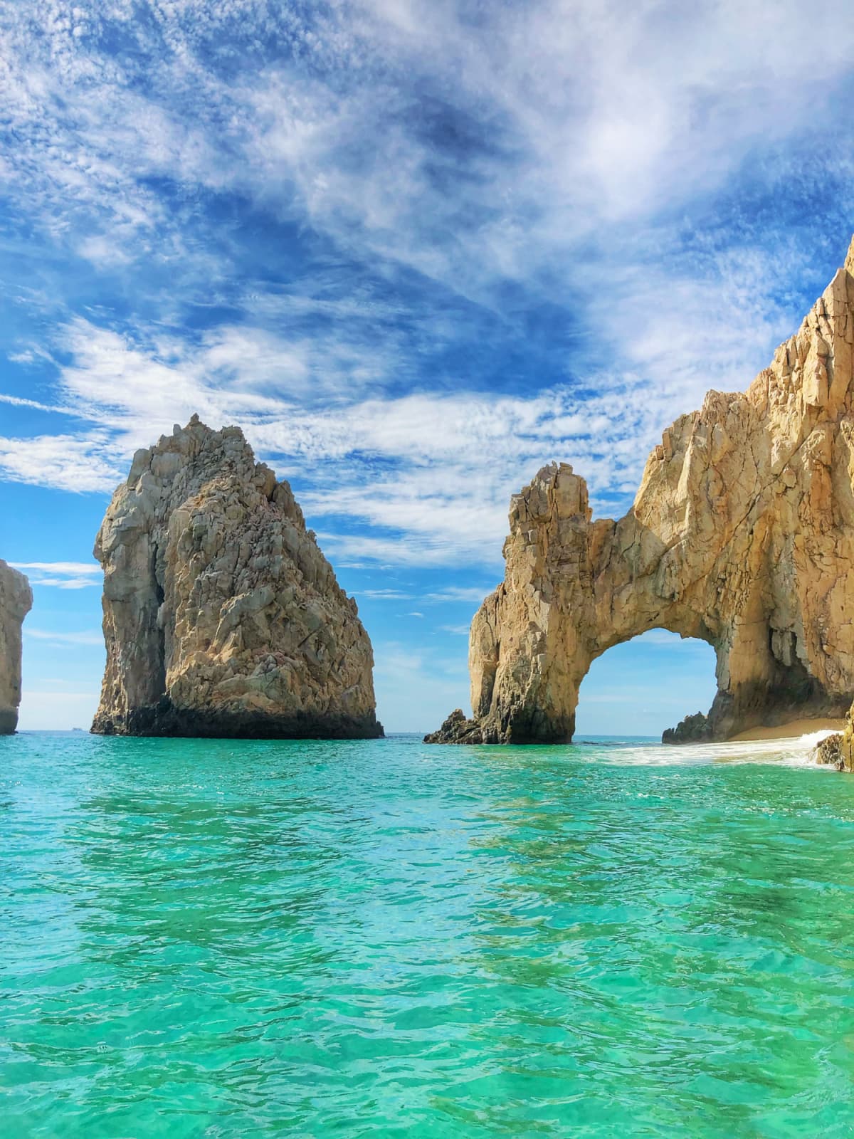 A sea stack and a sea arch in the aquamarine waters of Los Cabos Mexico
