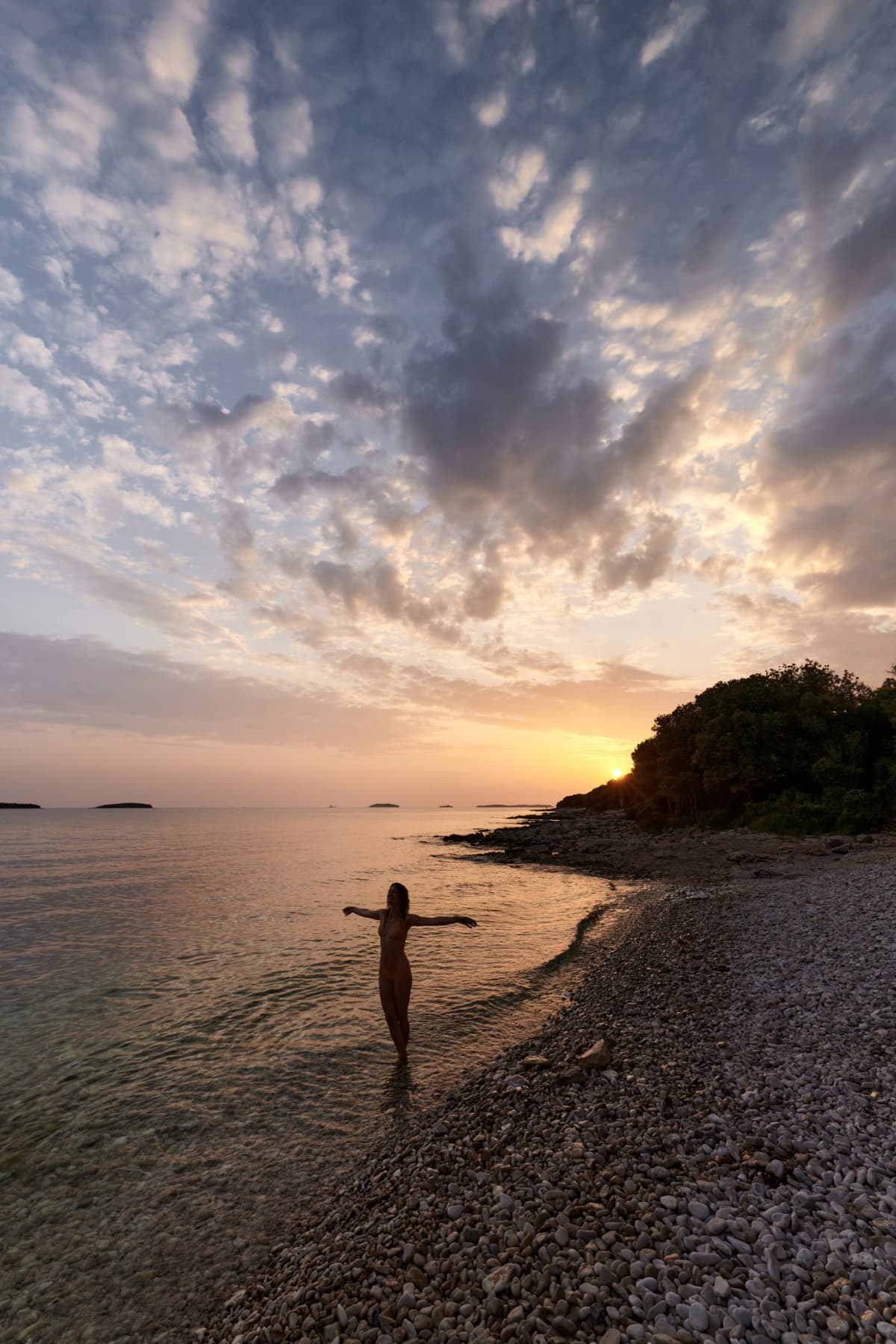 Woman standing alone in the waters of a secluded beach