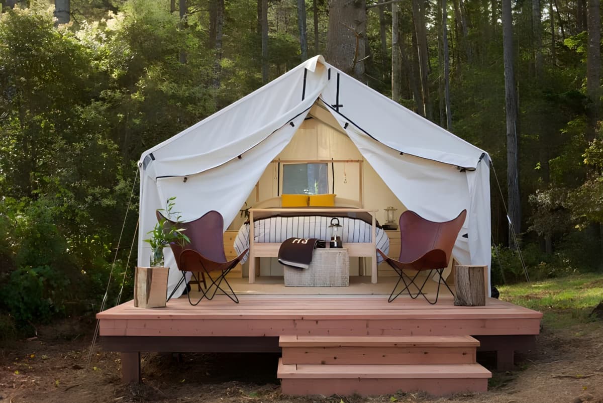 A glamping site with the doors pulled open to show a bedroom