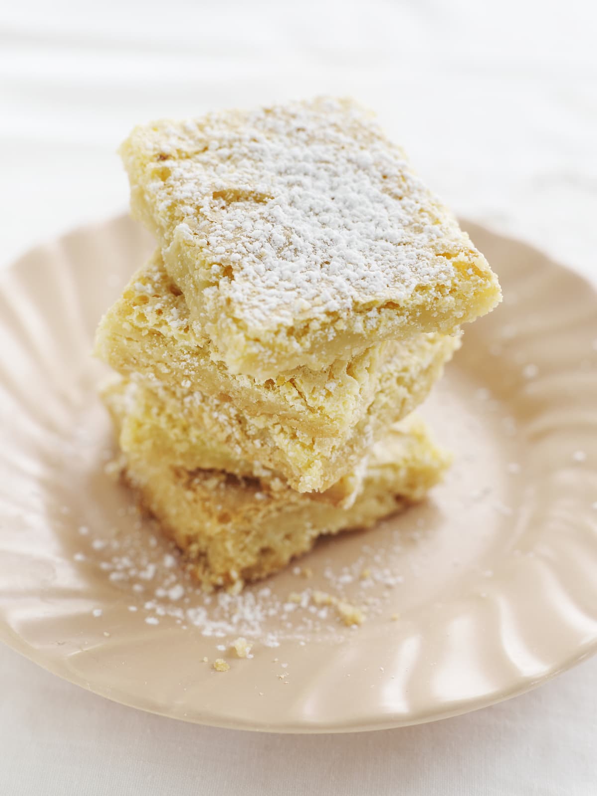 Lemon bars stacked on a plate