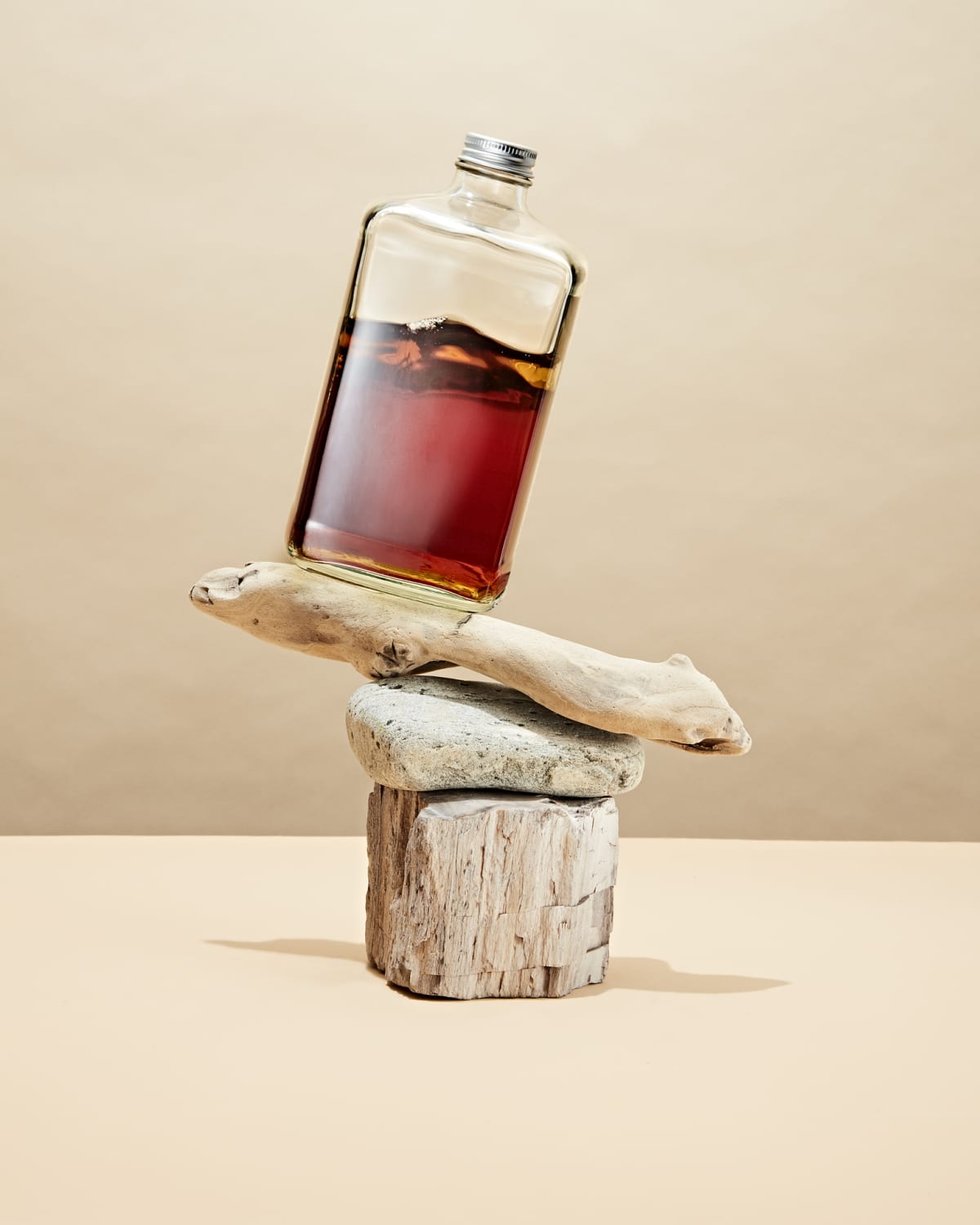 A bottle of bourbon rests on natural elements