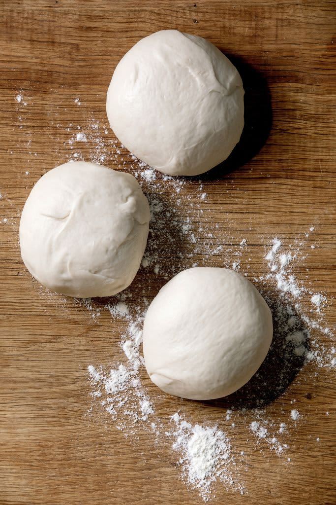 Dough for pizza cooking. Three balls of fresh homemade wheat dough on wooden table. Home baking. Flat lay, space. (Photo by: Natasha Breen/REDA&CO/Universal Images Group via Getty Images)