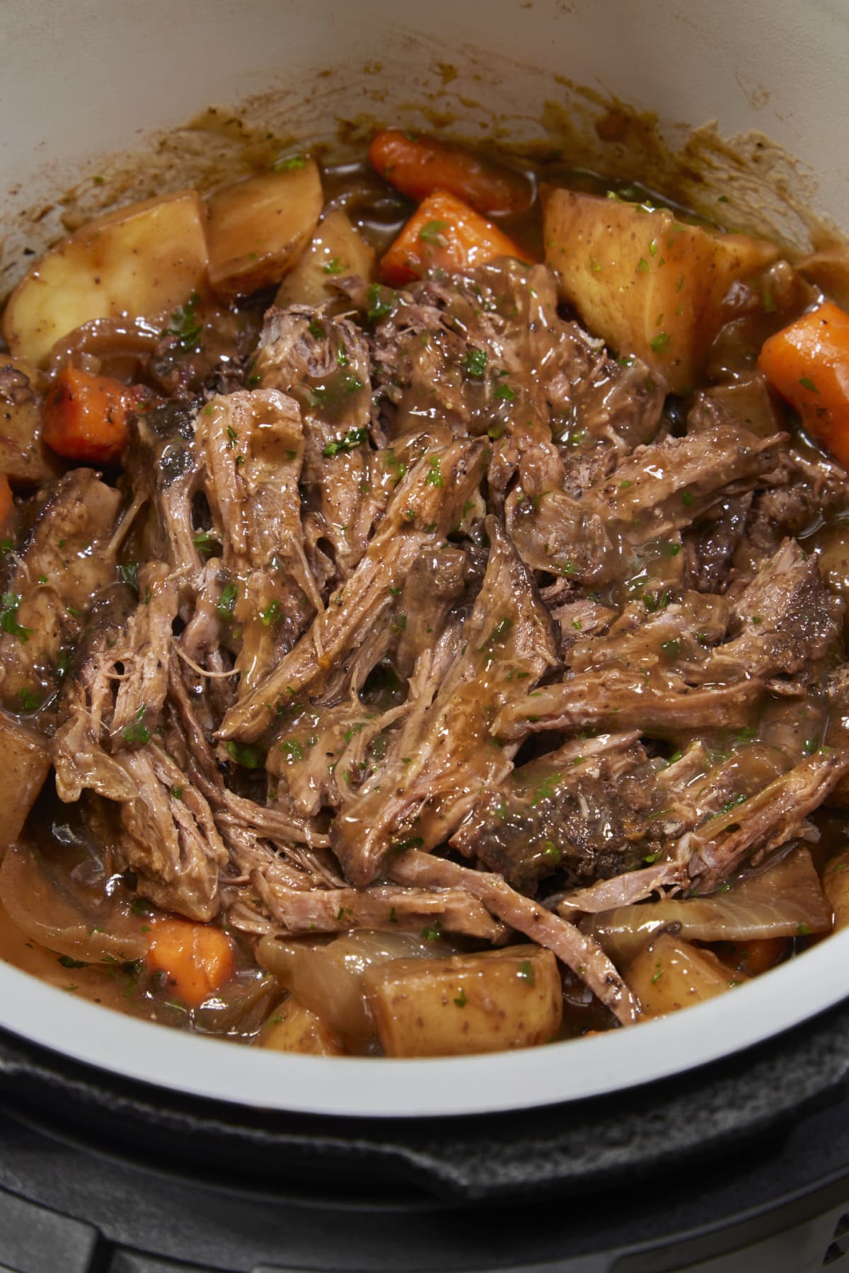Slow cooker pot roast with potatoes, carrots, celery, onions, and garlic