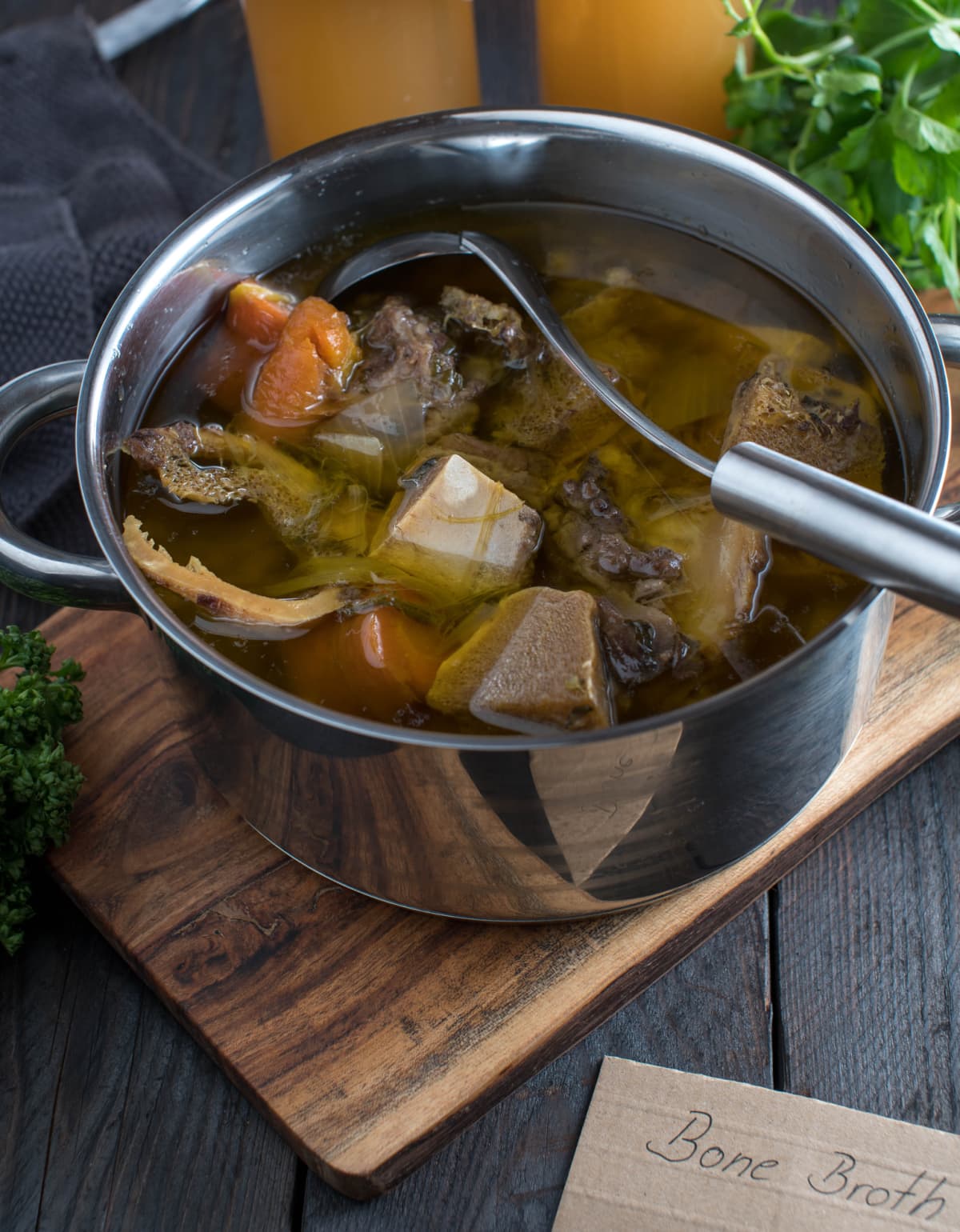 Bone broth with a ladle in a pot