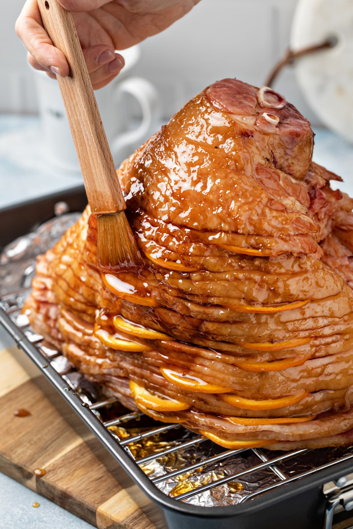 Spiral ham on a wire rack being glazed