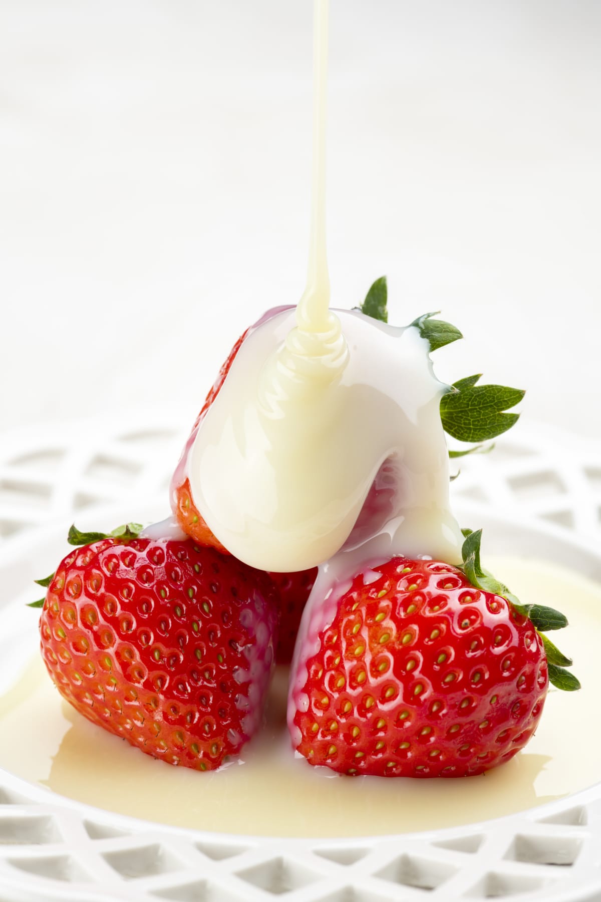 Drizzling condensed milk on strawberries