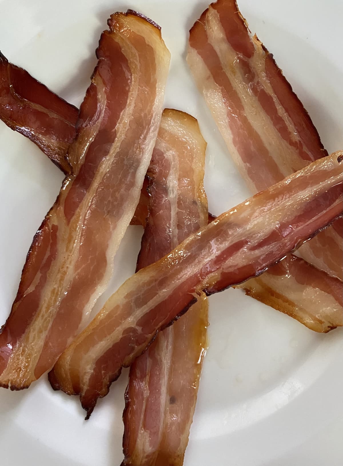 Strips of bacon on a white plate