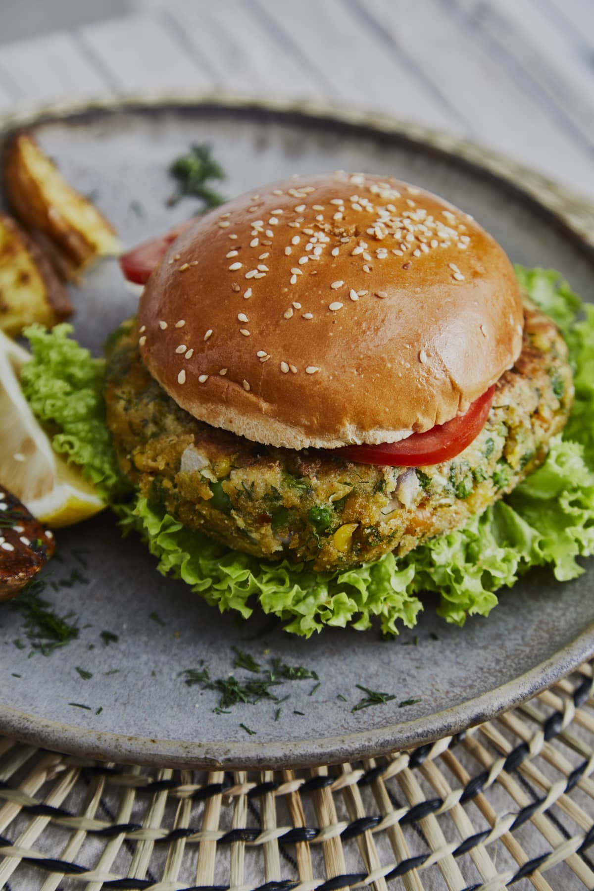 Vegan hamburger on a handmade ceramic plate, made of zucchini, green pea, seasoning, herbs and spices, close up