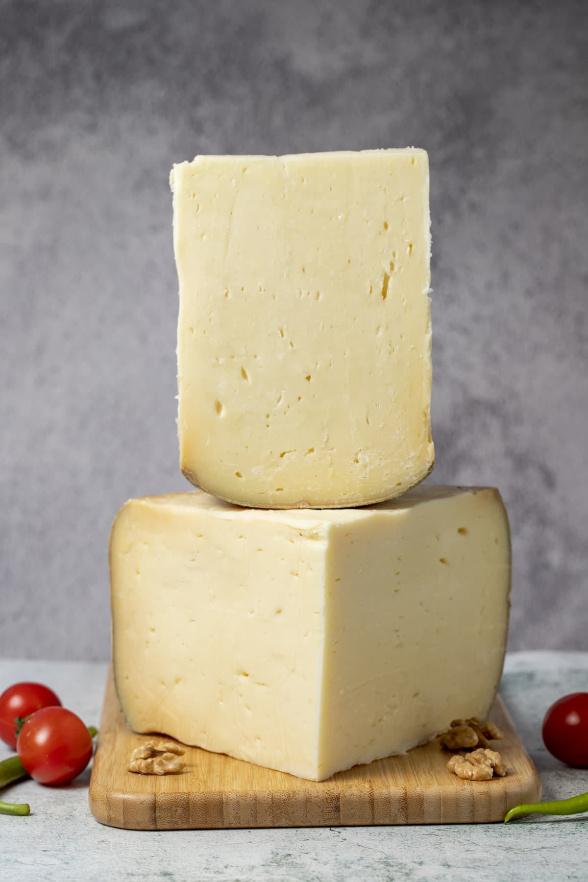 Large blocks of Gruyère cheese on a wooden cutting board