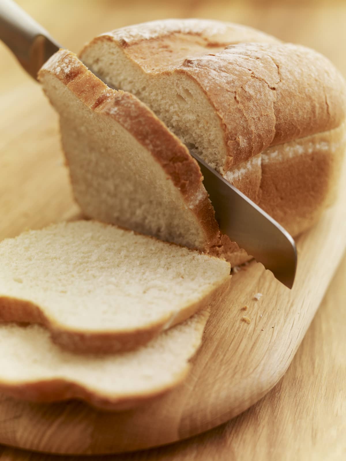 Knife slicing a loaf of bread