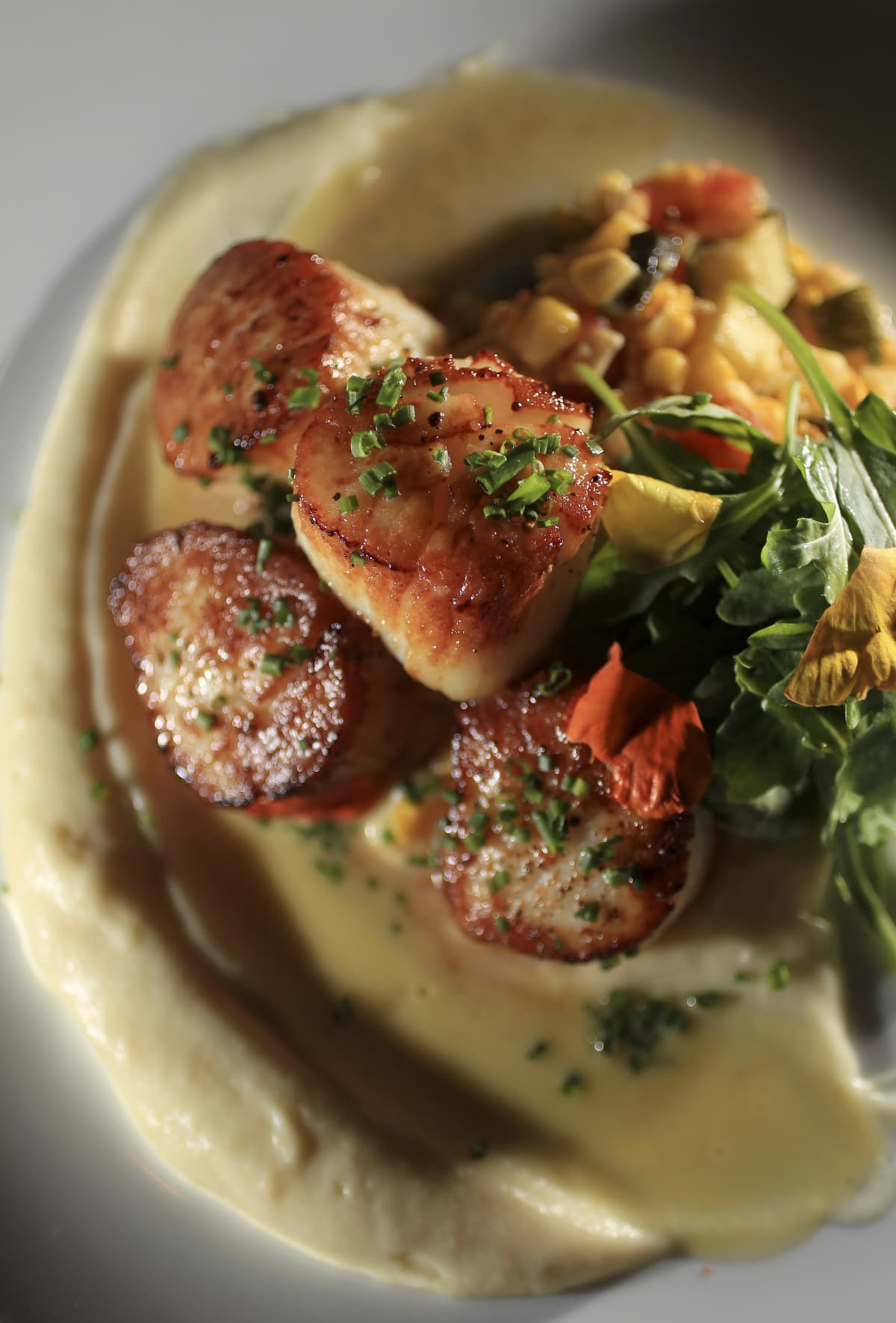MEDFIELD, MA - JULY 2: Pan-seared scallops: parsnip puree, summer vegetables succotash, and corn veloute from Zebra's in Medfield, photographed on July 2, 2013. (Photo by Essdras M Suarez/The Boston Globe via Getty Images)