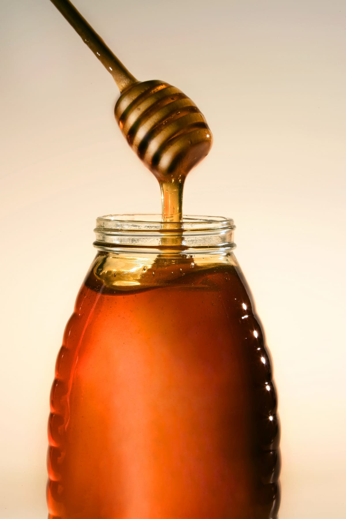 Fresh honey dripping from dipper