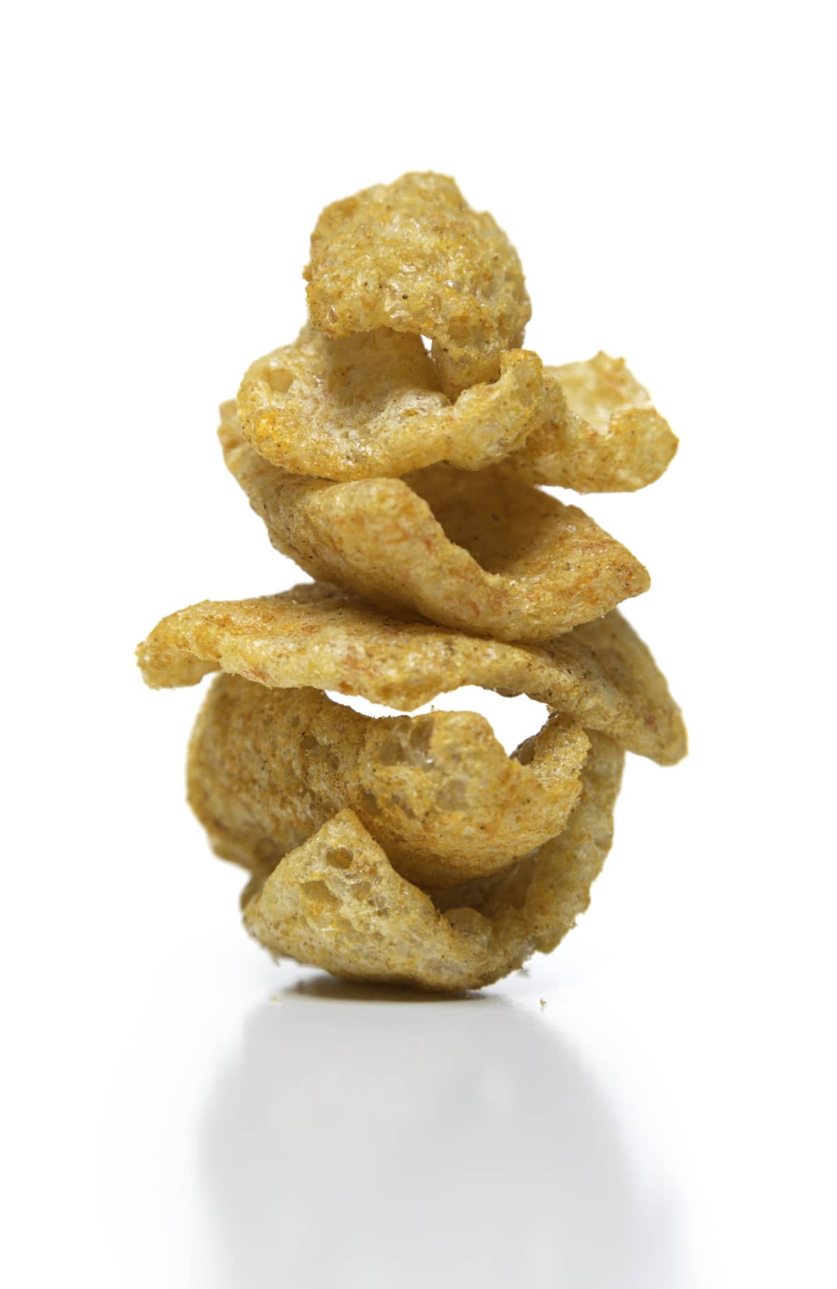 Stacked fried pork rinds on white background