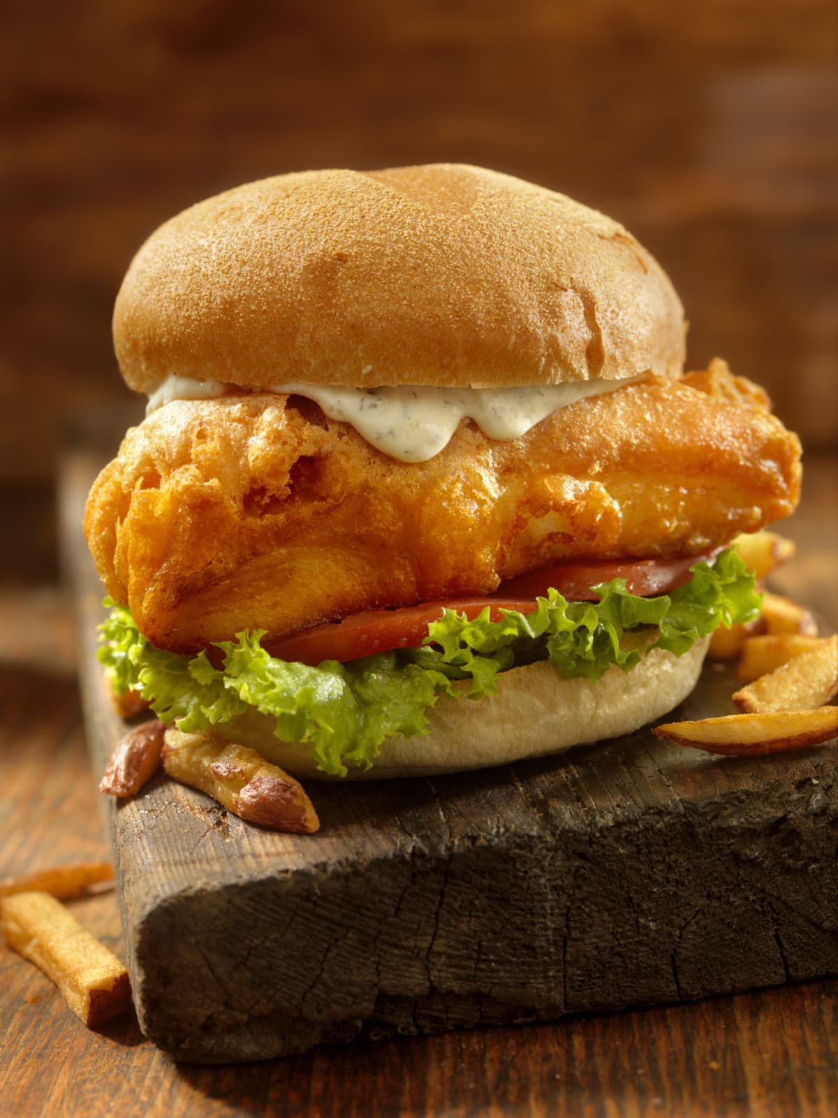 Beer Battered Fish Burger with Fries on a wooden board