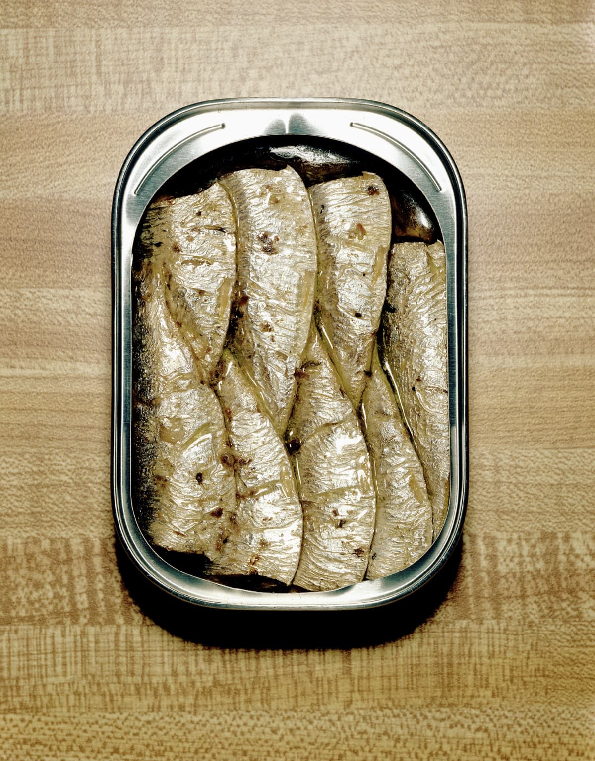 Open tin of sardines on table