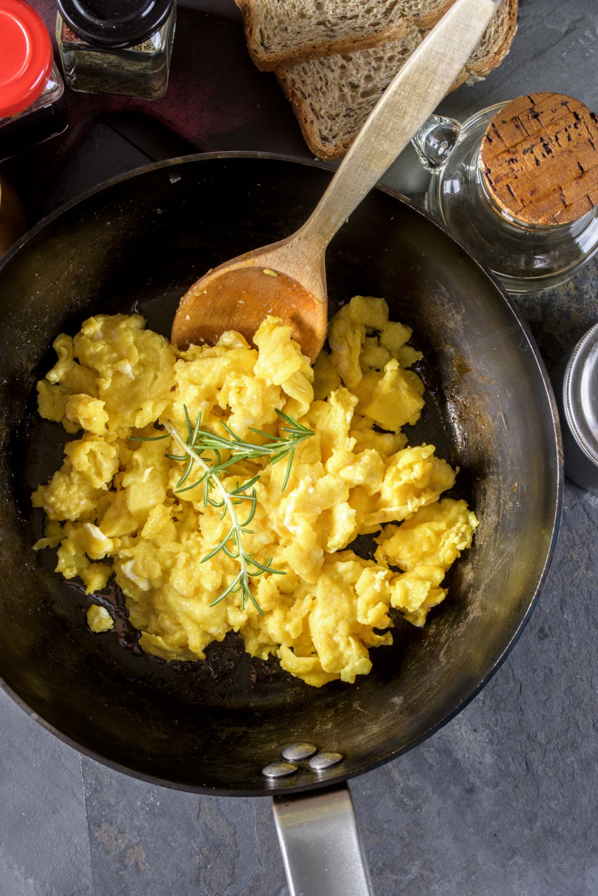 Scrambled eggs in wok with wooden spoon