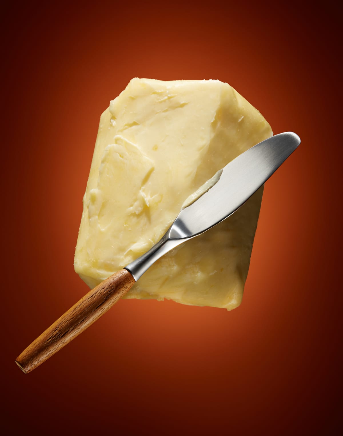 Block of butter and a butter knife in the air