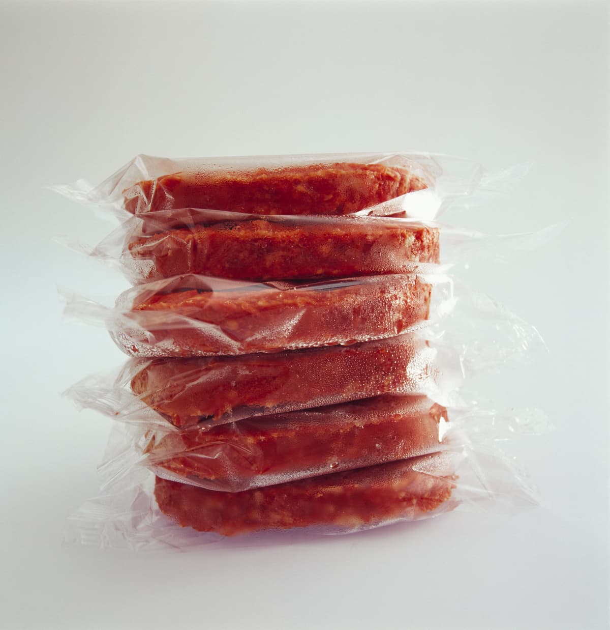 Several vacuum sealed beef patties in a stack