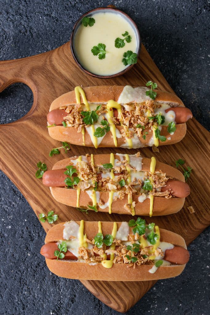 Hot dogs with cheese on a cutting board
