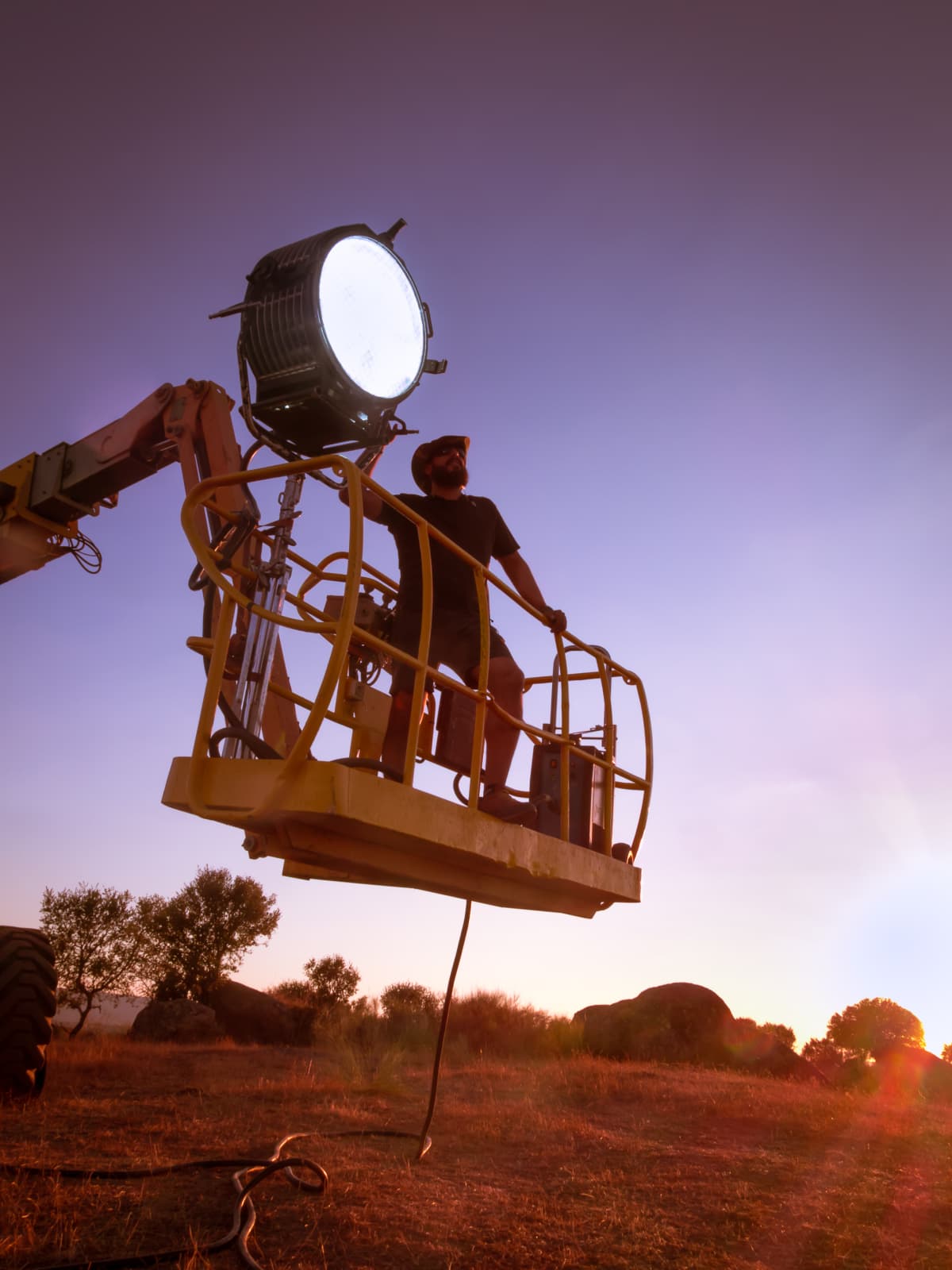 Film technician adjusting a light on set
