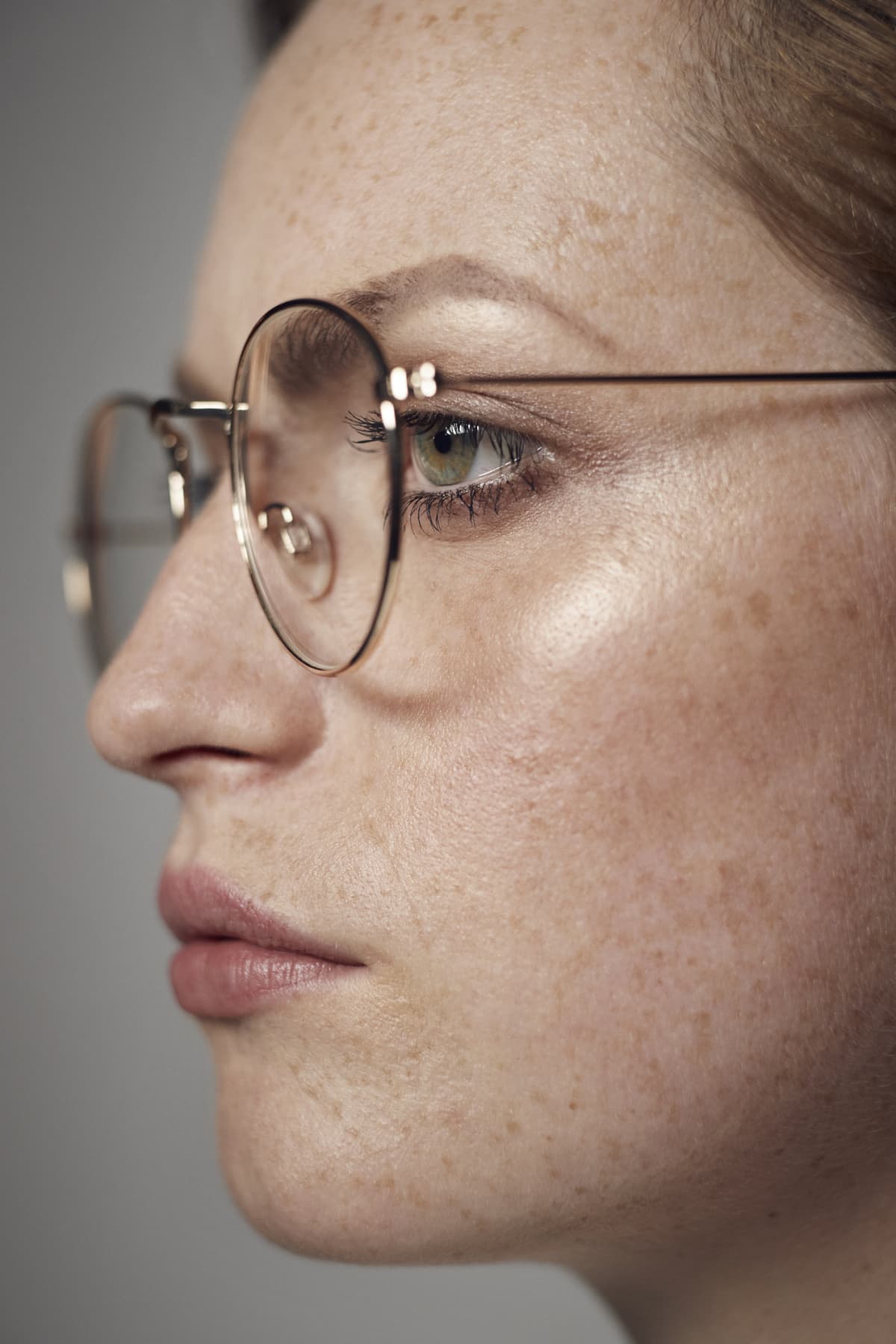 Close up sideview of woman wearing wire-framed glasses