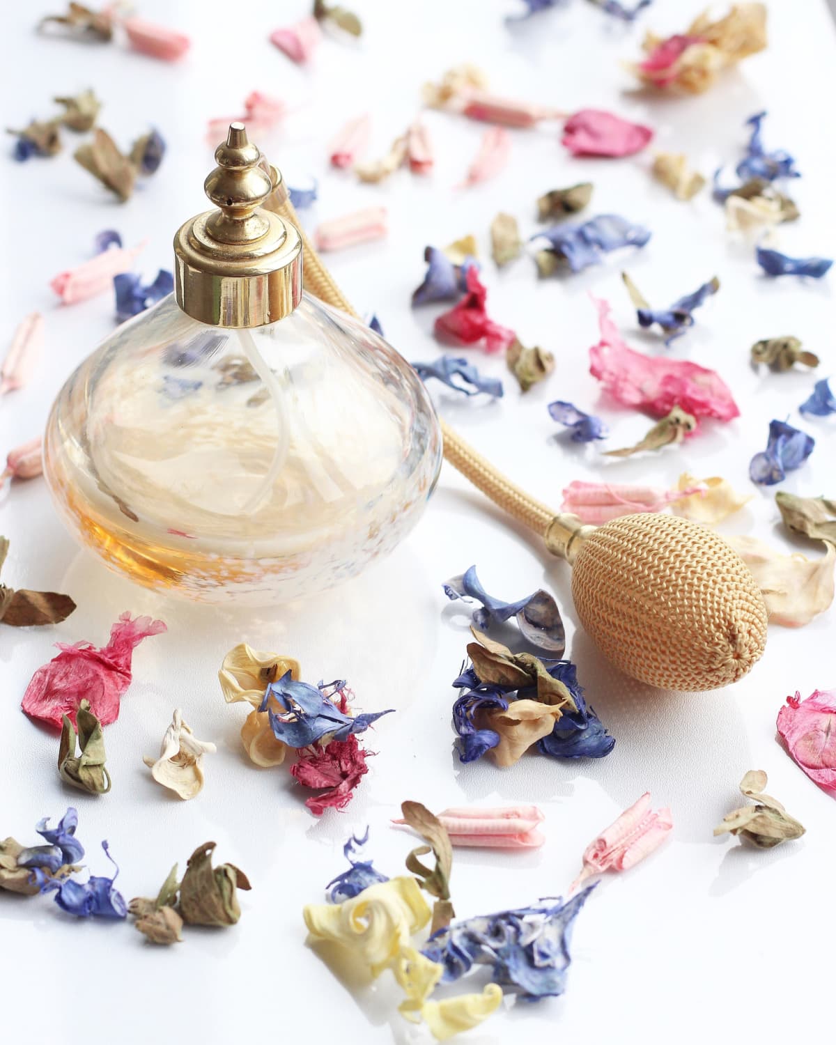 Perfume bottle surrounded by flower petals