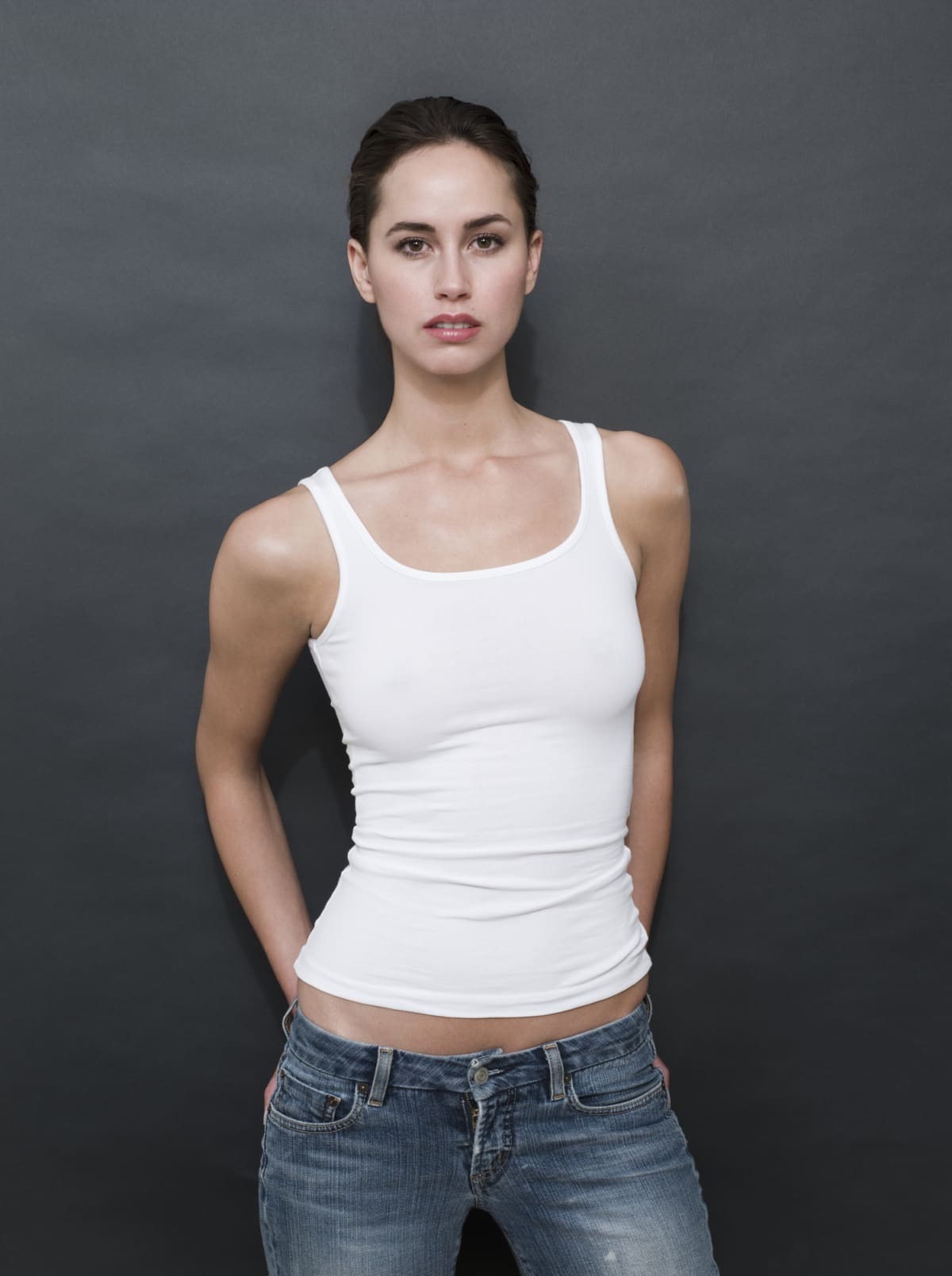 Woman posing in a white ribbed tank top