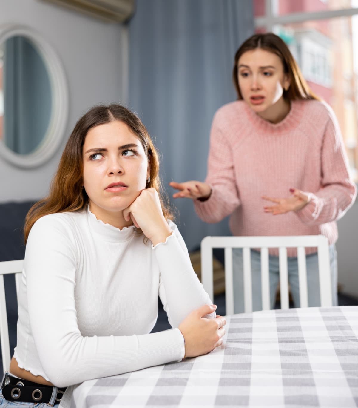 Young woman promptly ignoring another that is speaking to her
