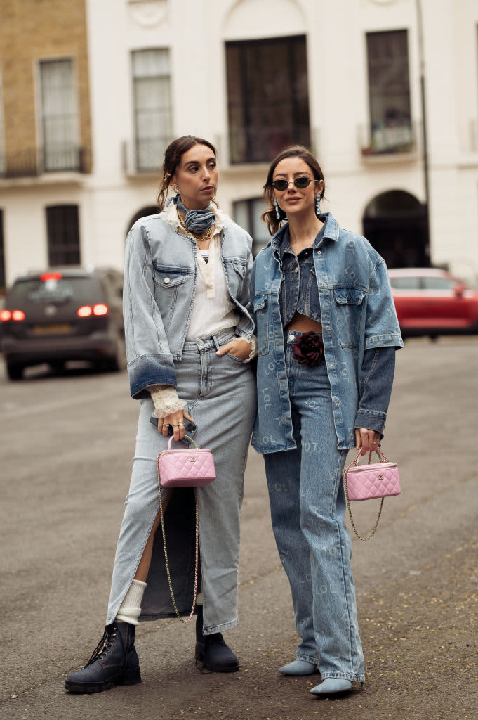 Two women wearing all denim outfits standing in the street