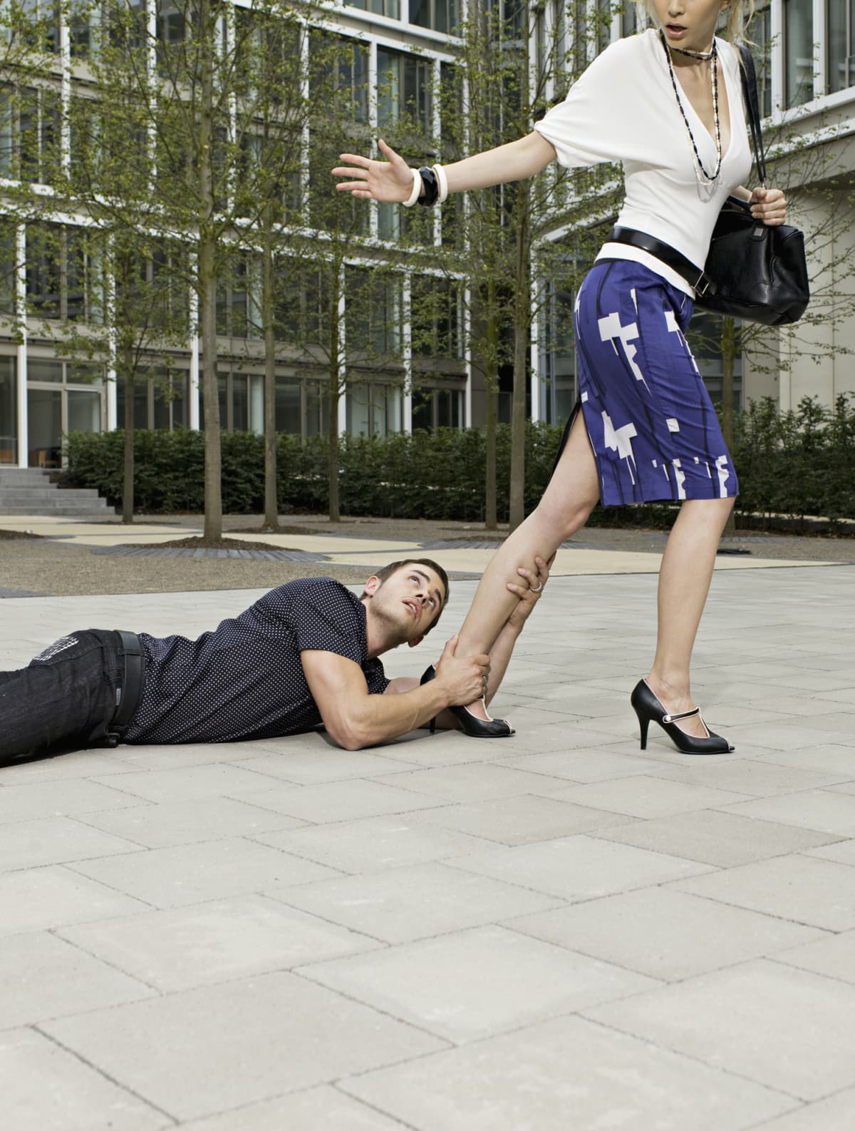 Man grabbing woman's leg as she tries to walk away