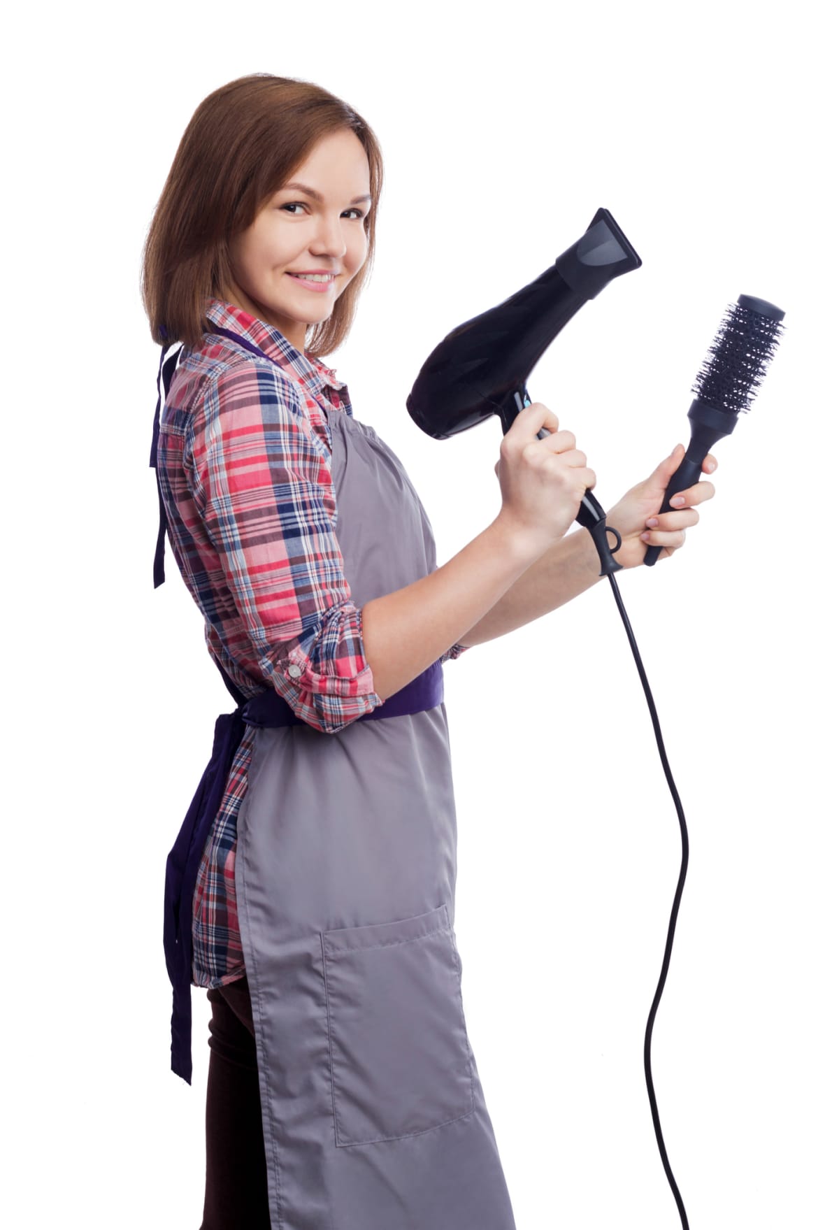 Happy female hairdresser holding hairdryer and brush isolated on white background