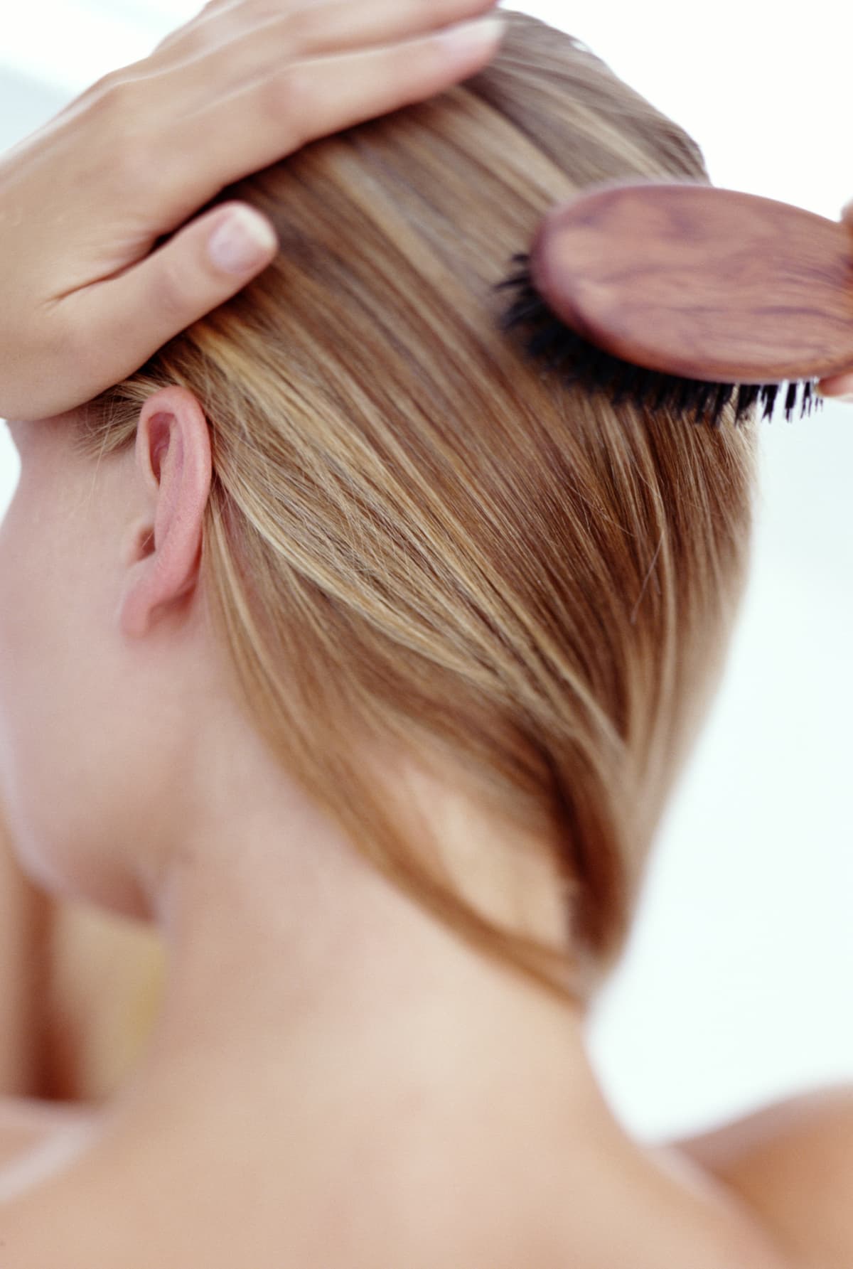 Close up of woman brushing her hair from the back