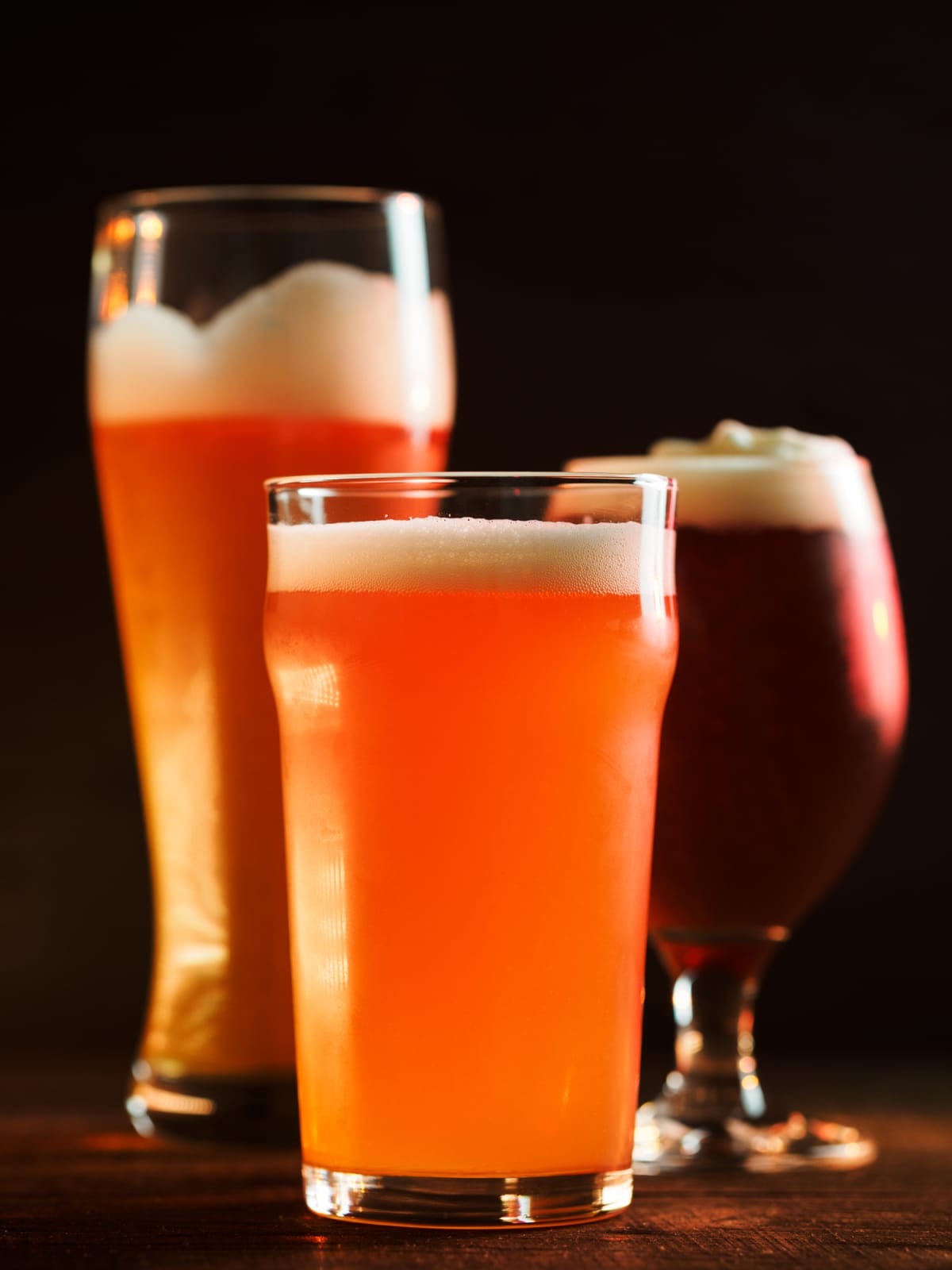 Beer and wine glass shadows against orange background