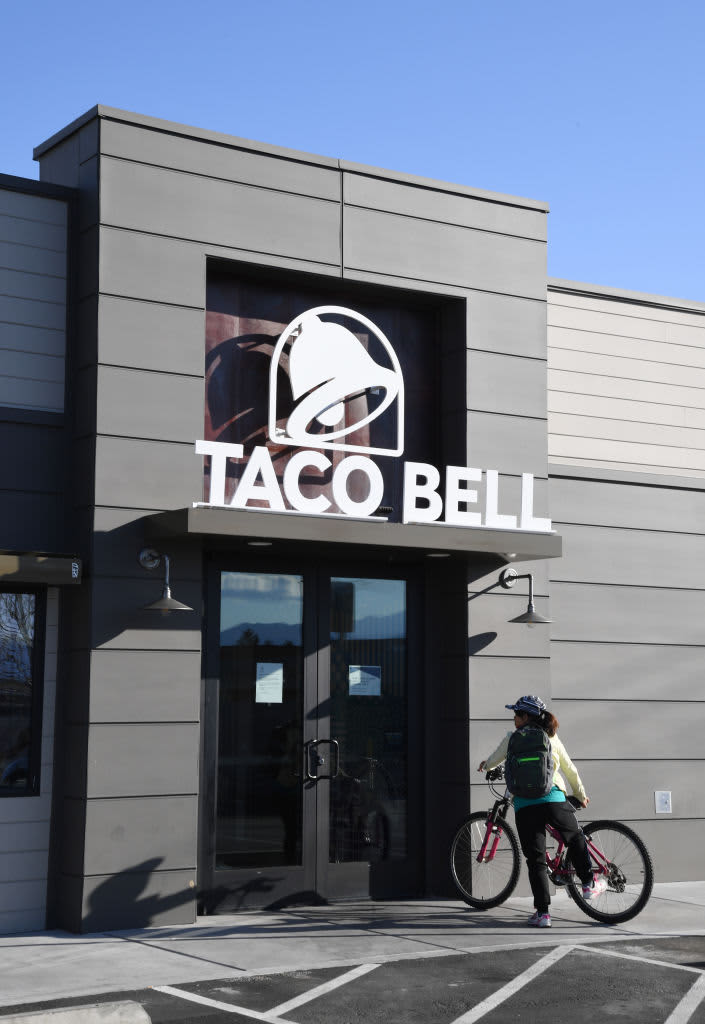 A sign is shown outside a Taco Bell that is temporarily closed in New Hyde Park, New York 07 December, 2006. A United States flag flies behind a Taco Bell sign at the Taco Bell in New Hyde Park, New York 07 December 2006. Taco Bell ordered scallions removed from its 5800 US restaurants 06 December after tests suggested they may be responsible for the E. coli outbreak that has sickened nearly four dozen people in three states. (Photo by Don EMMERT / AFP) (Photo by DON EMMERT/AFP via Getty Images)