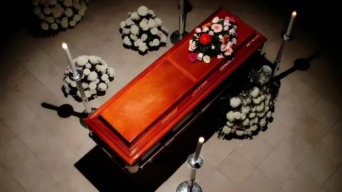 A wooden casket with flowers on top