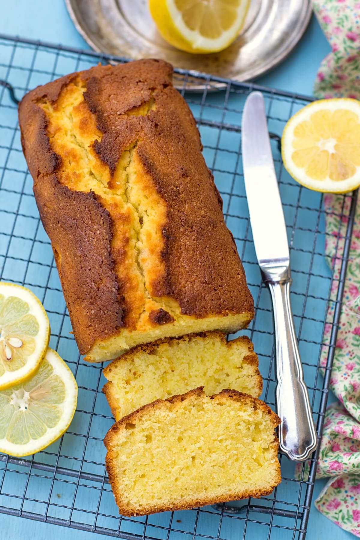 Moist and fluffy homemade lemon cake loaf on blue background