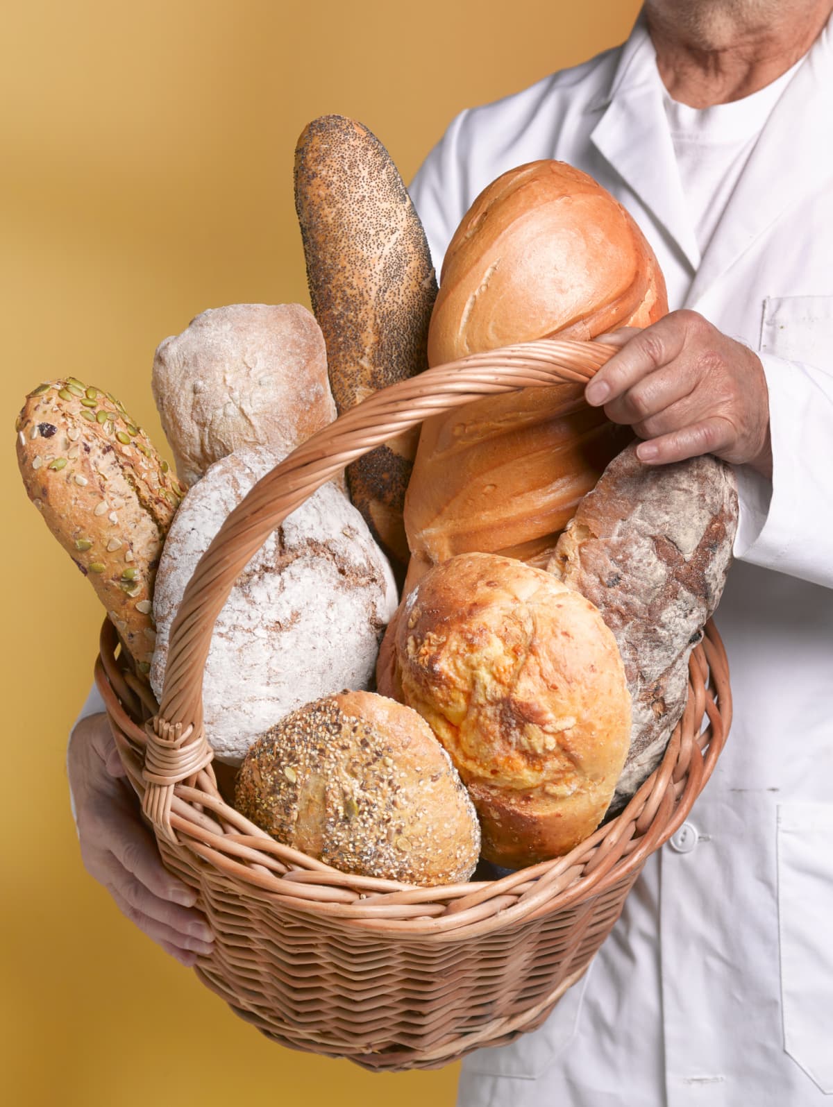 Baker holding a basket of bread loaves