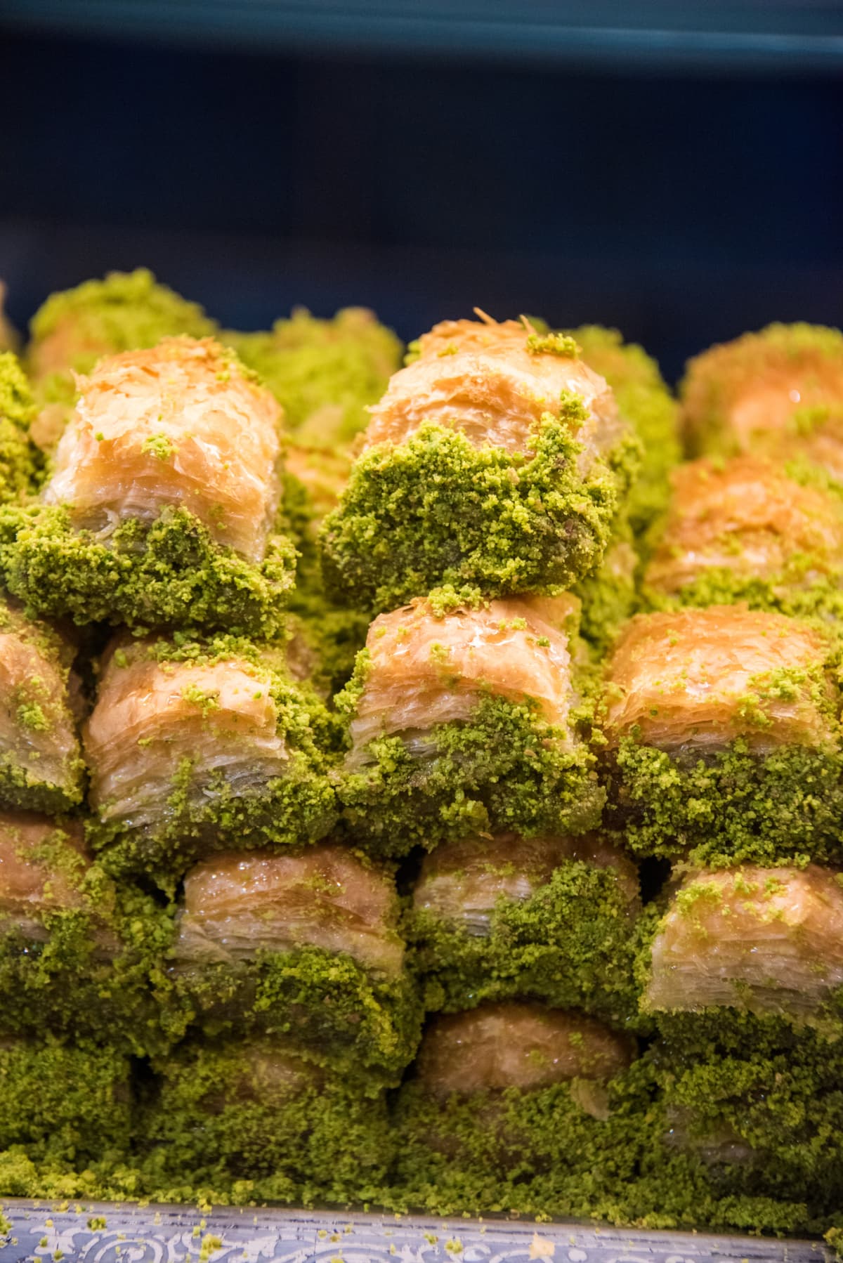 Turkish Pistachio Baklava, layered pastry dessert made of filo pastry, filled with chopped pistachio nuts, and sweetened with honey, on sale in a bakery in Haringey, North London, UK