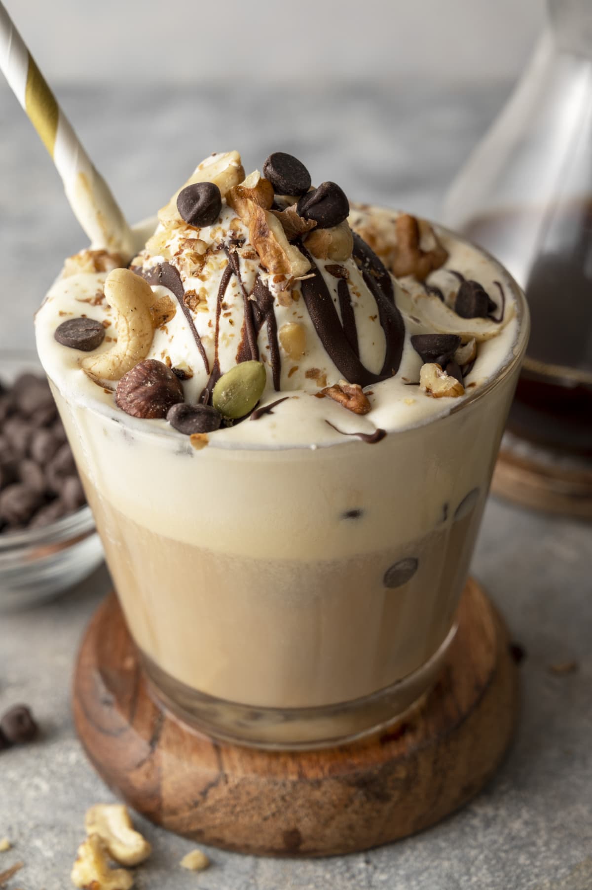 Coffee drink topped with ice cream, nuts, and chocolate chips