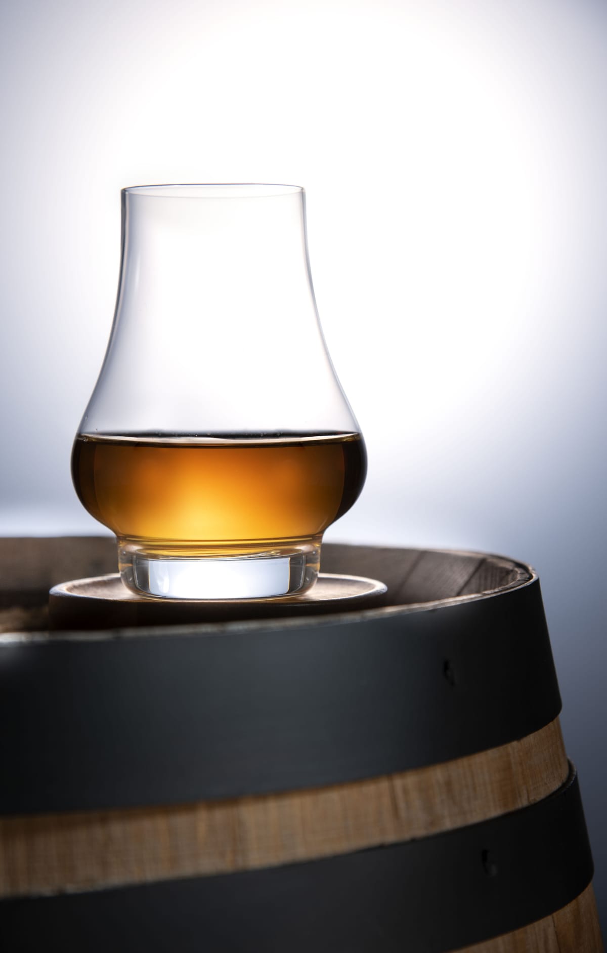Glass of Whisky on a whisky barrel with copy space at the top