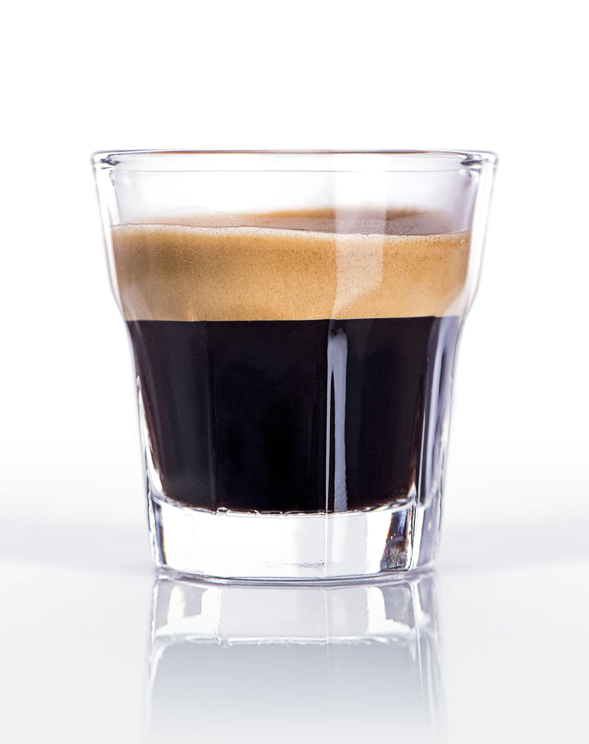 Close up of a glass of espresso on a white background
