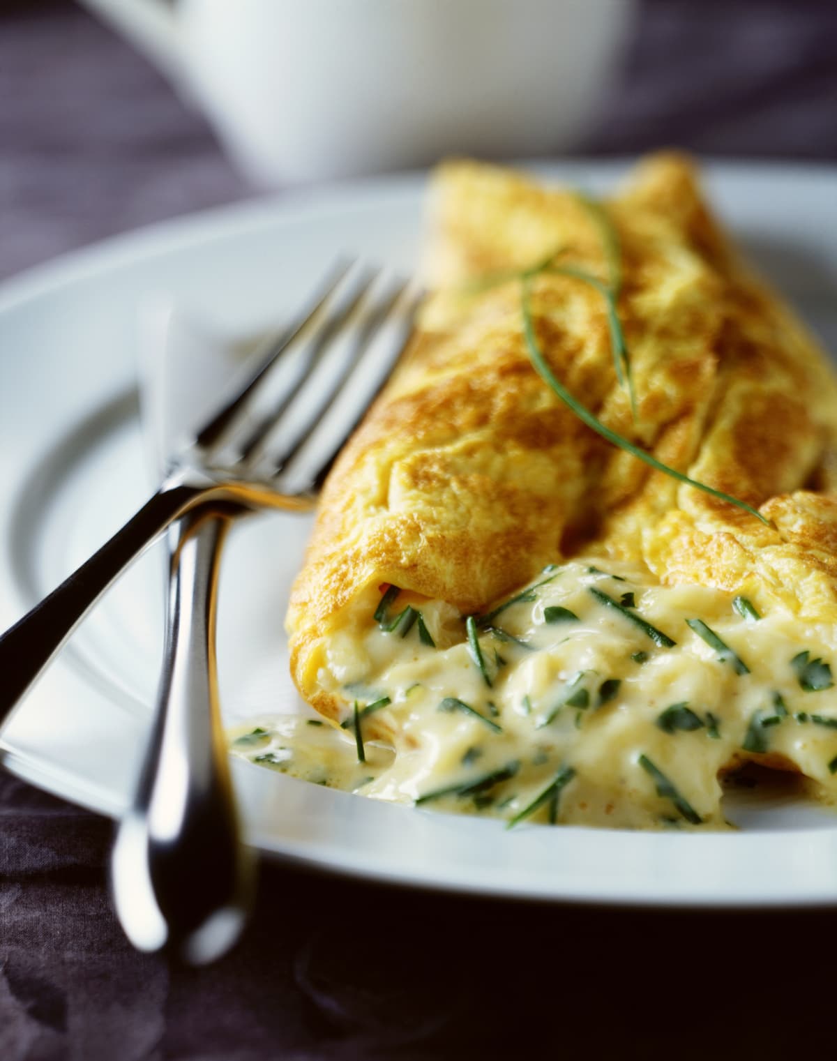Cheesy omelet on a plate with a fork