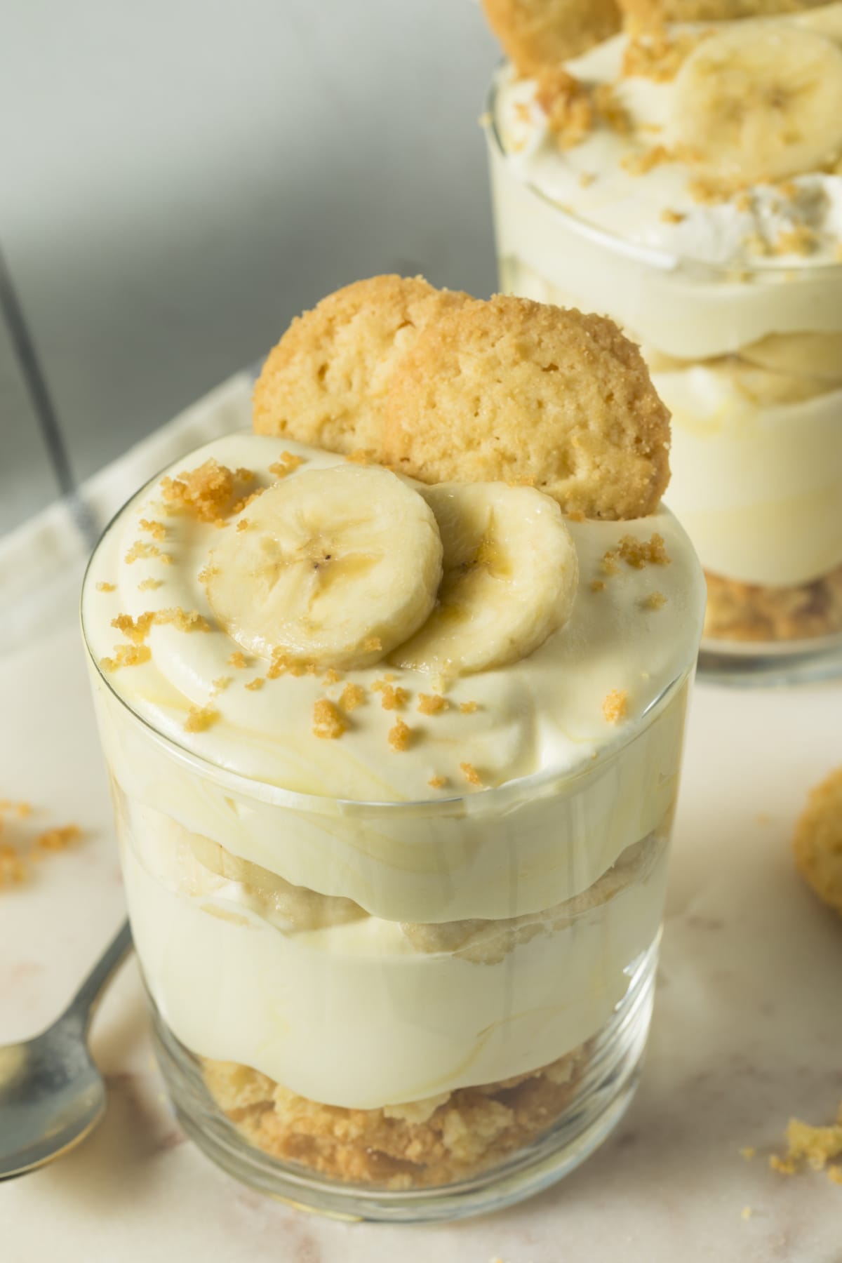 Glasses of banana pudding topped with bananas and cookies
