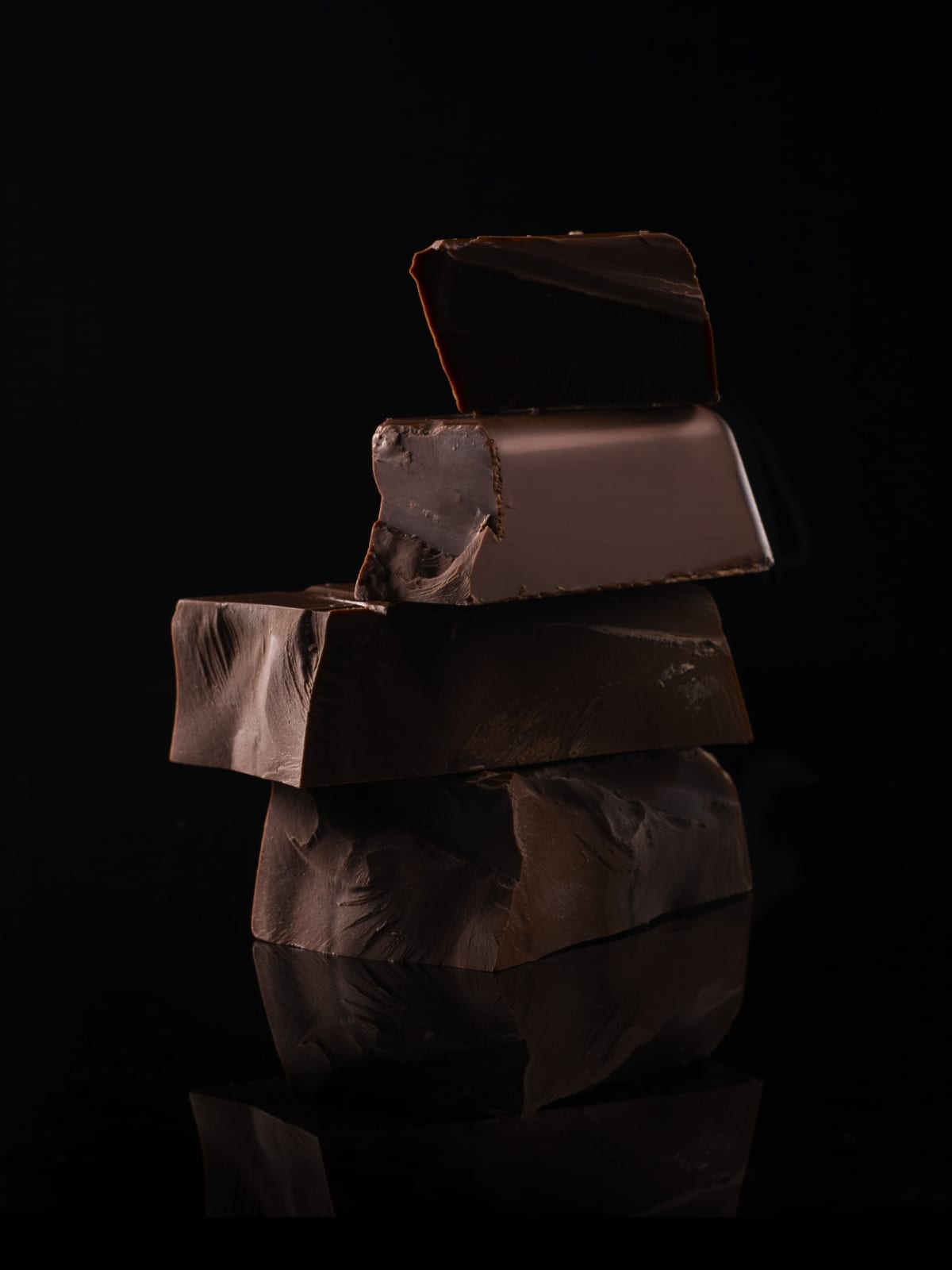 Piled up blocks of chocolate on black background