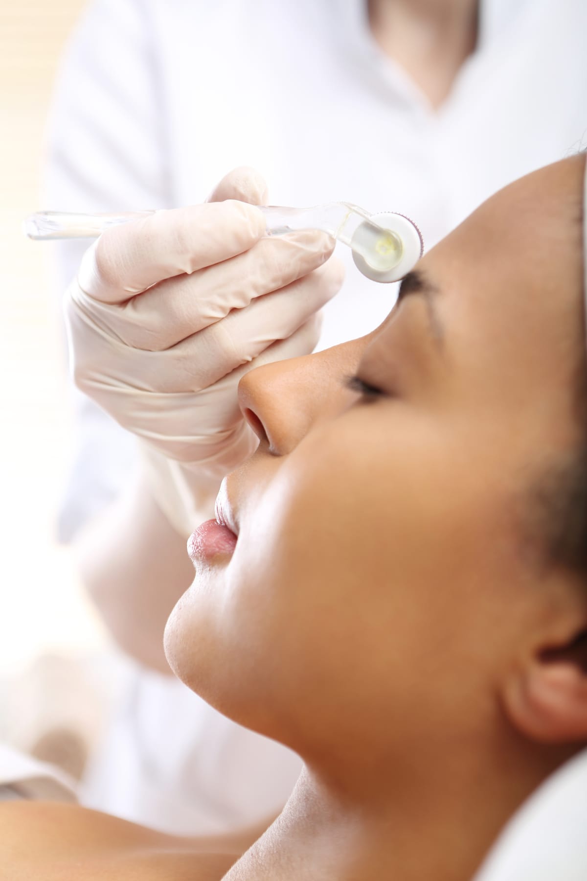 Beautician performs a needle mesotherapy treatment on a woman's face