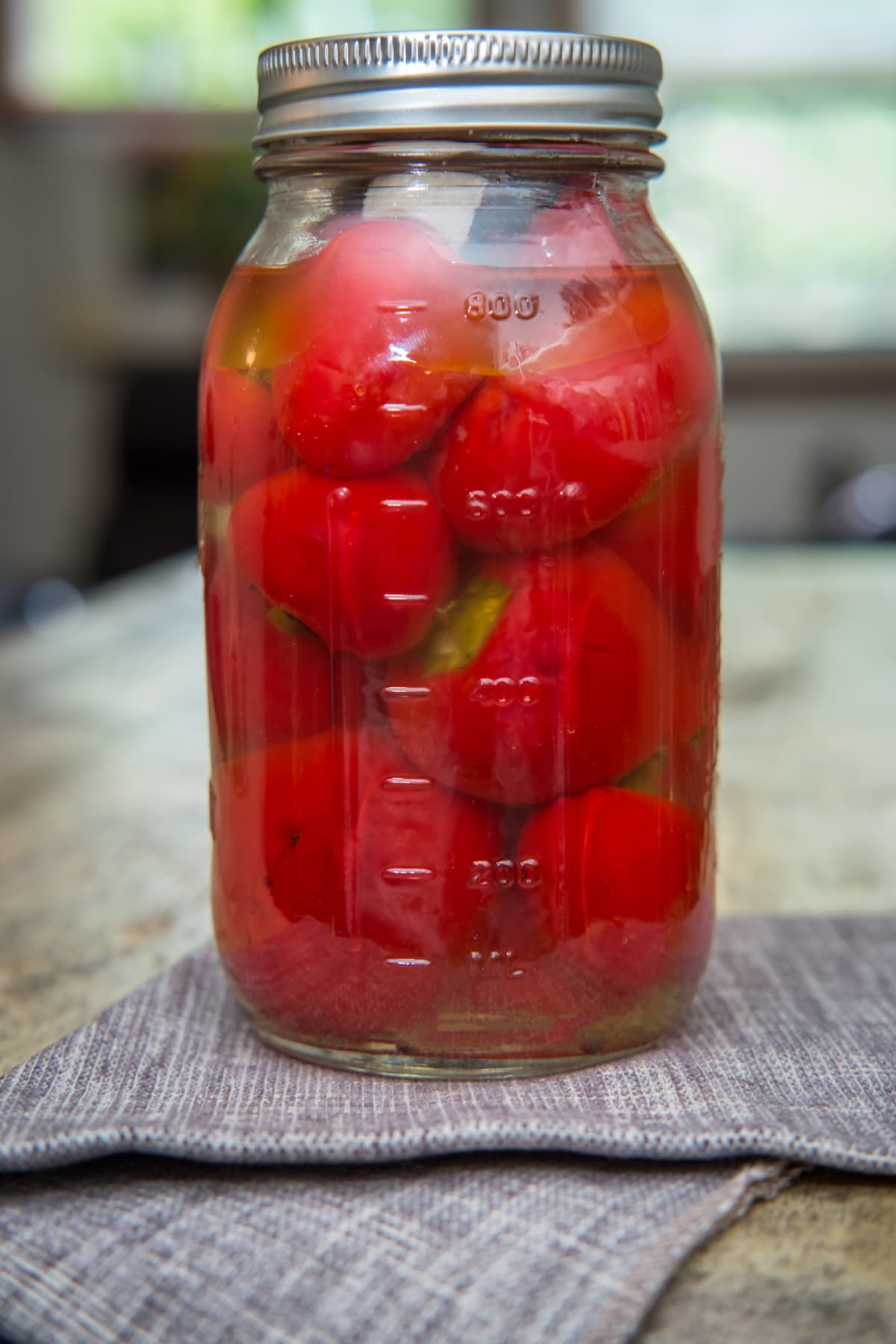Homemade rustic organic pickled cherry peppers on wooden table