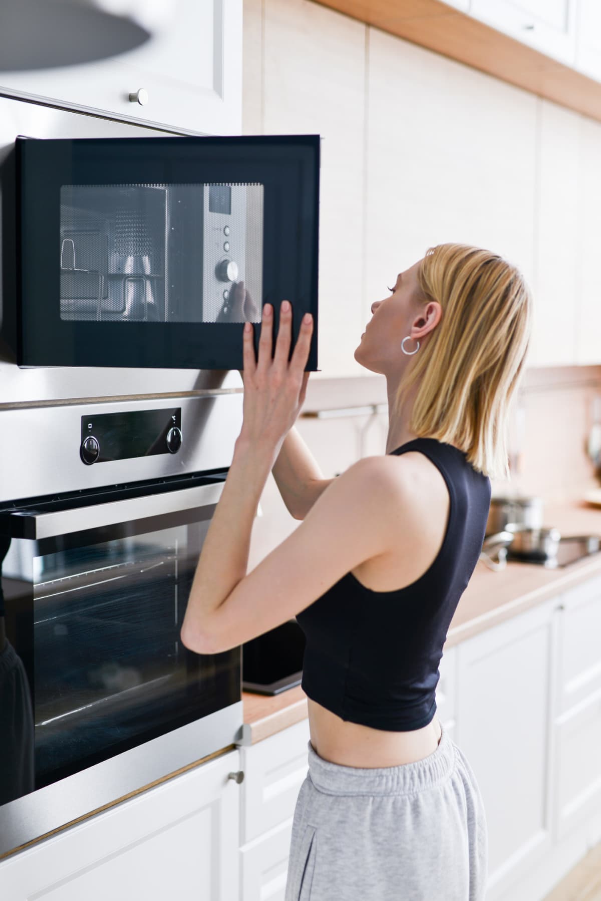 Woman heating food in the microwave.
