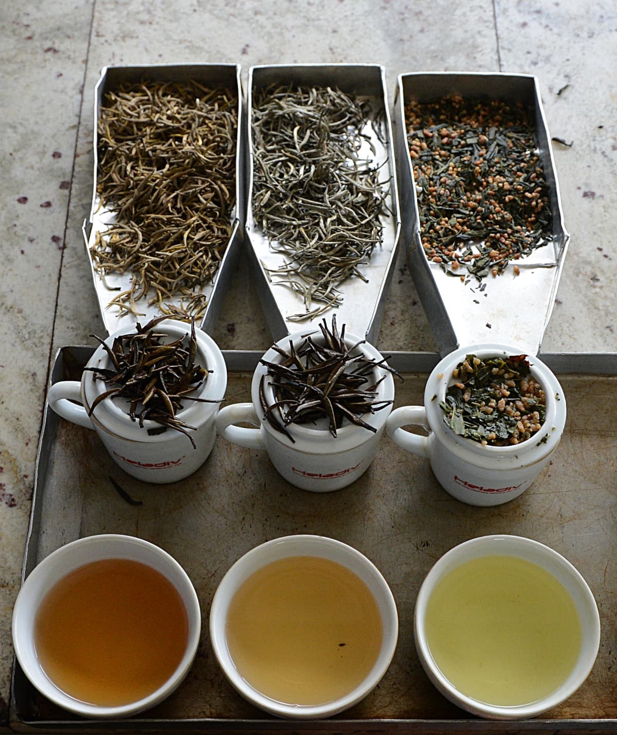 TO GO WITH Sri Lanka-tea-commodities-lifestyle-sex,FEATURE by Amal Jayasinghe
In a picture taken on March 14, 2013, Sri Lanka's exotic Golden Tips (L) and Silver Tips (C) and a Japanese Sencha (R) tea brewed on display at a factory in Kandana on the outskirts of Colombo.  A hot cup of Ceylon tea is better known as being soothing and relaxing, but Sri Lanka is now marketing its most profitable export as a luxury boost for the libido.    AFP PHOTO/Ishara S. KODIKARA        (Photo credit should read Ishara S.KODIKARA/AFP via Getty Images)